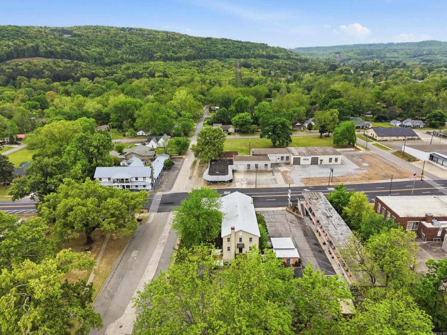 Spring Park Manor Unit A is a 3 story townhouse offering a unique downtown opportunity on the corner of iconic Spring Park. Ground floor includes living room with fireplace & ceiling fan + kitchen w brkfst bar &  half bath. There's also a fenced patio off the living room that's perfect for a small pet. The 2nd floor suite with fully renovated bath enjoys tile shower & floors as well as tub. 3rd floor has great mountain views. Amenities feature ample closet space & private bath w tile shower & floors. Design details in this home include elevator access + extra wide staircases w travertine tile & hardwood floors throughout. Zoned climate controls supported by 2 HVAC units for central heat & air ensure year round comfort.  There's also covered entry, private patio, balcony overlooking the park and detached, assigned parking. Proximity to Greer's Ferry Lake, Little Red River, Eden Isle, & Sugarloaf Mountain make this well thought out home the perfect spot to enjoy all lake life has to offer including easy access to 3 golf courses, world class trout fishing, dining, shopping, & healthcare. Walk to cafes, boutique shopping, banking, and the Gem Theater