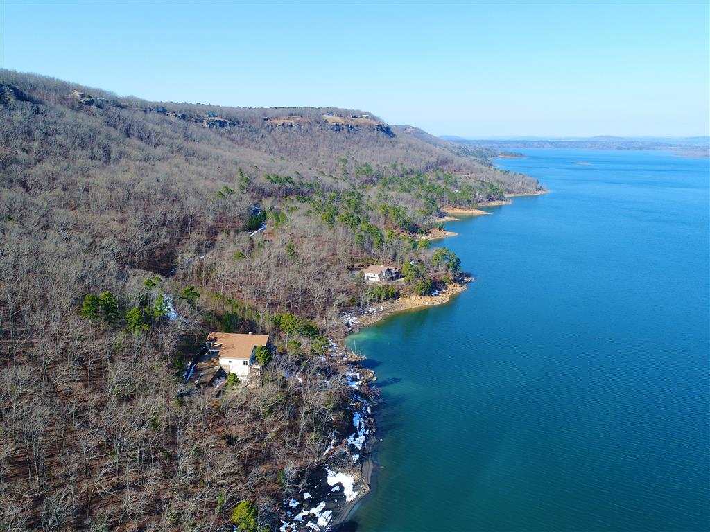 This 9,927 sq. ft., 5 bed, 5.5 bath mansion sits on 12.43 wooded acres & is simply exquisite! With 4 different decks/patios overlooking the 700 feet of lake frontage, the focus is on the stunning 180 degree views of Greers Ferry Lake. Inside, the home boasts 4 stories, a professional kitchen large enough to handle the largest groups, 4 different living areas, a towering rock fireplace, a wine cellar and much more! Each bedroom has its own on-suite, but the luxurious master suite is not to be out done!