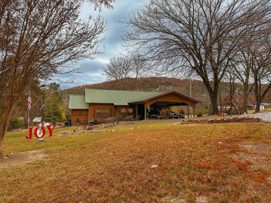 No. 25002 Lodge-style charm near the White River!  This 2 bed, 2 bath home offers 1,492 sq ft with an office that could be a 3rd bedroom, spacious kitchen, two dining areas, cozy living room, and a den with a wall of windows. Enjoy outdoor living with a screened-in porch, double post-and-beam carport, 2 storage buildings, fenced enclosure for pets, and beautifully landscaped grounds with gated drive.  Home underwent a complete remodel in 2010 with new electrical, plumbing and so much more. Practical features include city water, an old water well, gutters & drain system, storm shelter, and propane. Set back from the highway, the long front lawn provides privacy and reduces road noise. All this less than 5 minutes from the White River and the historic Swinging Bridge at Sylamore Creek! Perfect as a full-time home, second home, or VRBO. Seller will consider a one-year lease back. Don’t miss this rare opportunity to own a versatile property in the heart of the Ozarks.  $389,900.00