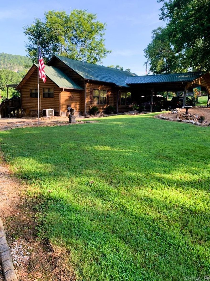 No. 25002 Lodge-style charm near the White River!  This 2 bed, 2 bath home offers 1,492 sq ft with an office that could be a 3rd bedroom, spacious kitchen, two dining areas, cozy living room, and a den with a wall of windows. Enjoy outdoor living with a screened-in porch, double post-and-beam carport, 2 storage buildings, fenced enclosure for pets, and beautifully landscaped grounds with gated drive.  Home underwent a complete remodel in 2010 with new electrical, plumbing and so much more. Practical features include city water, an old water well, gutters & drain system, storm shelter, and propane. Set back from the highway, the long front lawn provides privacy and reduces road noise. All this less than 5 minutes from the White River and the historic Swinging Bridge at Sylamore Creek! Perfect as a full-time home, second home, or VRBO. Seller will consider a one-year lease back. Don’t miss this rare opportunity to own a versatile property in the heart of the Ozarks.  $389,900.00