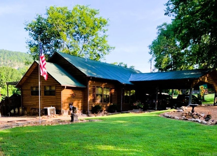 No. 25002 Lodge-style charm near the White River!  This 2 bed, 2 bath home offers 1,492 sq ft with an office that could be a 3rd bedroom, spacious kitchen, two dining areas, cozy living room, and a den with a wall of windows. Enjoy outdoor living with a screened-in porch, double post-and-beam carport, 2 storage buildings, fenced enclosure for pets, and beautifully landscaped grounds with gated drive.  Home underwent a complete remodel in 2010 with new electrical, plumbing and so much more. Practical features include city water, an old water well, gutters & drain system, storm shelter, and propane. Set back from the highway, the long front lawn provides privacy and reduces road noise. All this less than 5 minutes from the White River and the historic Swinging Bridge at Sylamore Creek! Perfect as a full-time home, second home, or VRBO. Seller will consider a one-year lease back. Don’t miss this rare opportunity to own a versatile property in the heart of the Ozarks.  $389,900.00