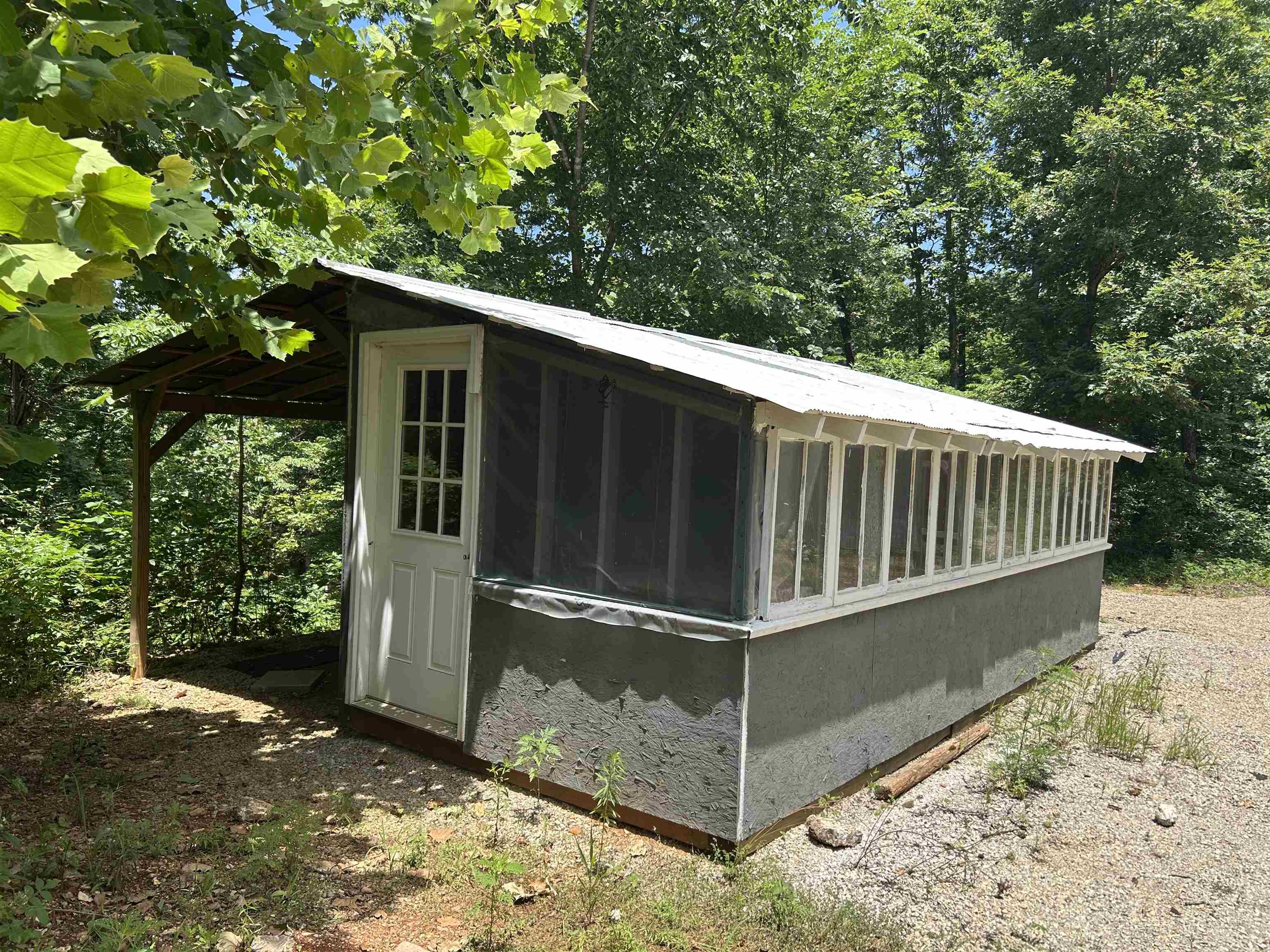 One-Room Cabin on 10 Acres± in the Beautiful Ozarks! This 10 acres±, property is mostly wooded and offers privacy, convenience, and great potential. The land has multiple buildings, including a one-room cabin with a covered lean-to, perfect for a rustic retreat or weekend getaway. A second structure—formerly used as a partial greenhouse—could easily be converted into a second cabin or guest quarters. The property also features a nice carport for your vehicle, boat, or outdoor gear, along with an additional storage building for tools or equipment. With community water, electric, high speed Internet and easy county road access, the essentials are already in place. Located just minutes from the Cold Spring access on the Spring River, and near Mammoth Spring State Park and the Mammoth Spring National Fish Hatchery. This property is ideal for outdoor lovers, campers, or anyone looking to create a peaceful hideaway in the Ozarks.