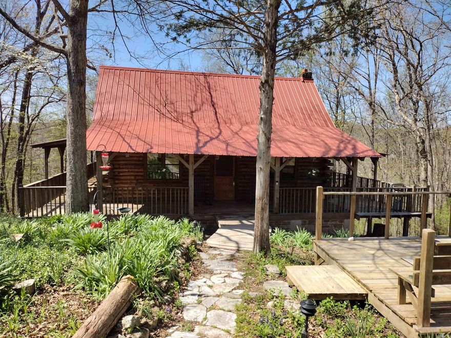 Nestled in the woods, this beautiful log cabin boasts great views and Roasting Ear Creek frontage, making an excellent choice for a getaway or full-time residence, providing a serene setting to enjoy nature, with all contents included, priced to sell quickly.