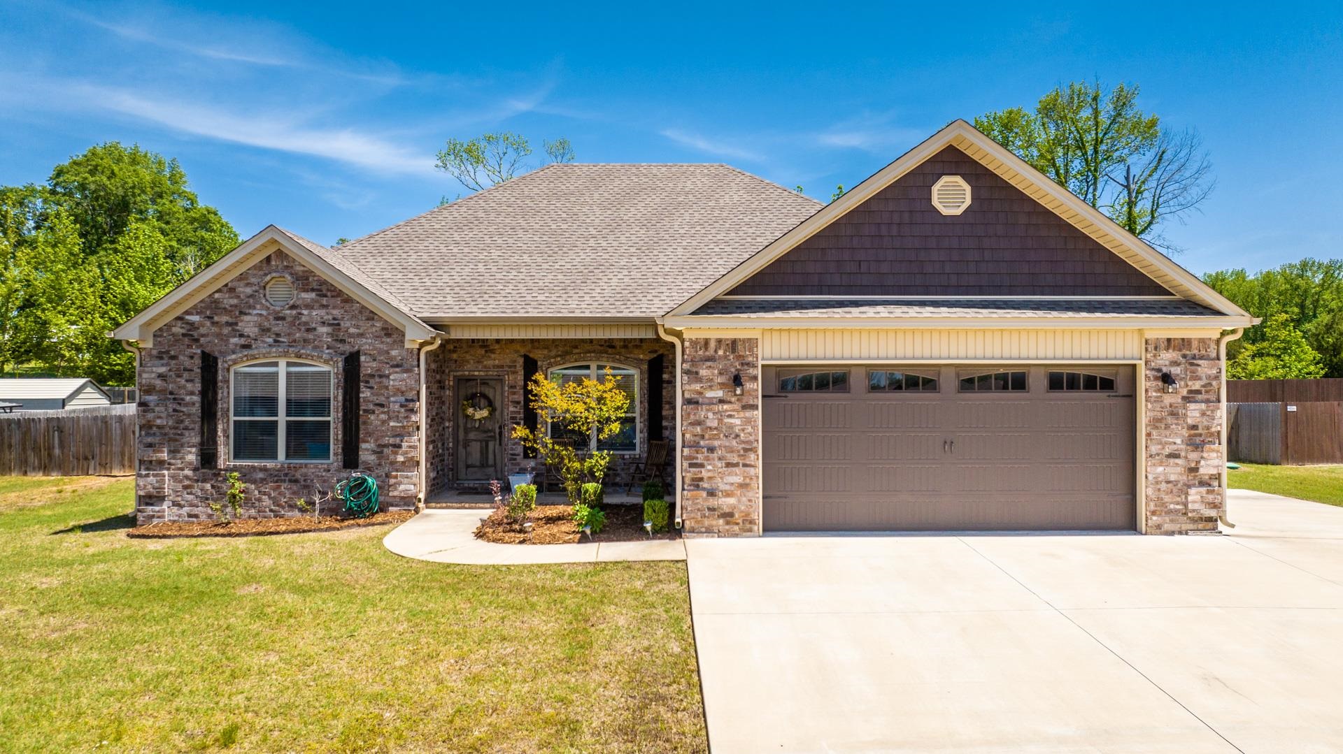 As good as new, take a look at this 4 bedroom, 2.5 bath home that has been well maintained. Open concept, living room/dining area has soaring ceilings, fireplace, luxury vinyl plank flooring. Kitchen has gorgeous granite, decorative backsplash, pantry, stainless appliances, breakfast bar. Primary bedroom is separate from the other 3, has a nice walk-in closet with sliding door, separate tub and tiled shower with rain head shower head, double sinks. Covered patio overlooks fenced back yard. Gutters, window blinds, extra parking pad, guest bathroom has 2 sinks, backs up to trres for added privacy!