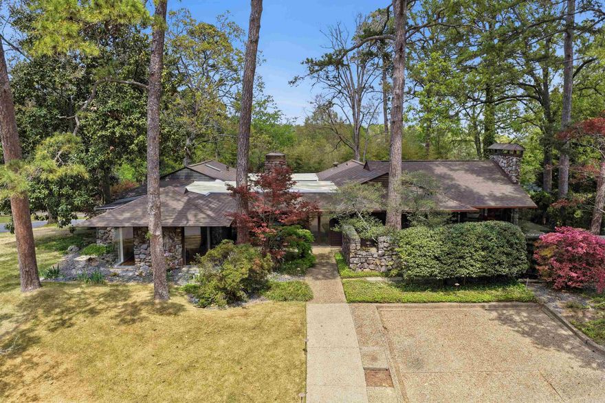 This authentic and iconic mid-century modern residence is ideally positioned on .57 of an acre and offers timeless design, exceptional privacy and a floor plan suited for both everyday living & entertaining on one level. Built in 1963, this architectural gem features an open layout with a separate dining room, formal living room with wood-burning fireplace, and a spacious den centered around a private courtyard and patio with incredible natural light. The vaulted family room is surrounded by glass windows which opens to the patio. The kitchen features granite countertops, Viking gas cooktop, double ovens, wine fridge & a large island w/ abundant storage. The private primary suite offers a renovated bathroom with double vanities, soak tub, walk-in shower & built-ins. An office, two additional bedrooms with two fully renovated bathrooms are also available. Downstairs offers a detached 4th bedroom suite of approximately 295 SF plus a 216 SF safe room. Outdoor amenities include a striking two-sided stone water feature and koi pond and multiple patio spaces for entertaining. Additional highlights include whole home generator, 2-car carport w/ extra parking & electric car charger.