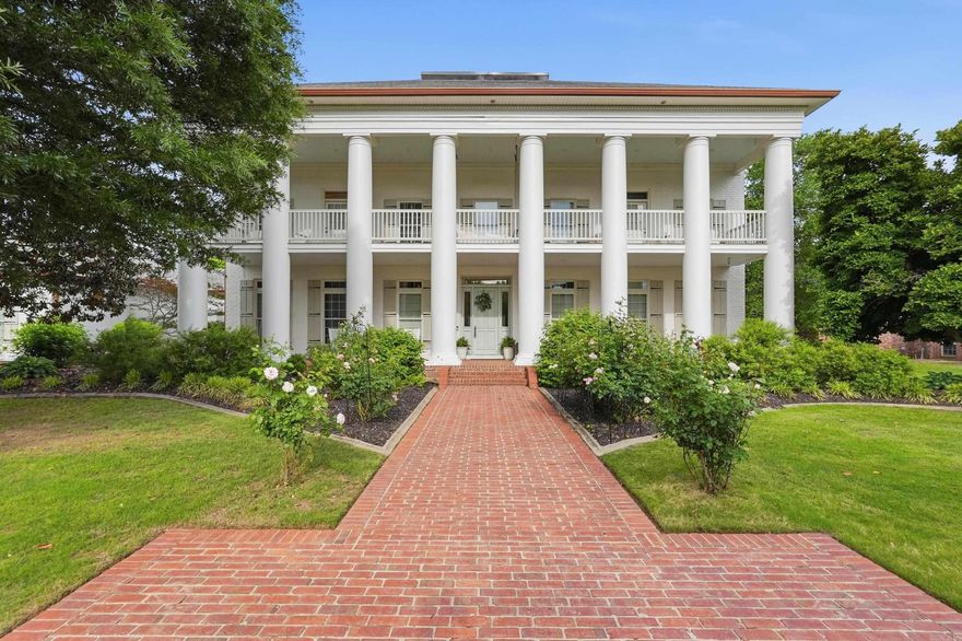 Roses are in full bloom & the pool is open. Welcome to resort-style living in this beautifully curated 2-story home, surrounded by mature Magnolias & fragrant David Austin English roses. Multiple covered porches, including a charming sleeping porch with a custom bed swing, offer inviting spaces to relax & unwind. The backyard is your own private resort, featuring an oversized heated saltwater pool with a shallow-end bench, a putting green & a shady hammock perfect for afternoon reading. Inside, the kitchen is a true showpiece with Fantasy Brown quartzite countertops, herringbone brick floor & premium appliances. A wood-burning fireplace adds warmth & character to two elegant living spaces. The primary suite opens to its own private balcony overlooking the pool. For utmost relaxation, enjoy the custom Jason hydrotherapy tub, offering a spa-like experience at home. A downstairs bedroom, full bathroom & additional living area with wet bar provide exceptional flexibility & could easily serve as a luxurious in-law suite. Located in the heart of one of the fastest growing cities in the country, this pairing of luxury & convenience is the ultimate investment in your next phase of life.