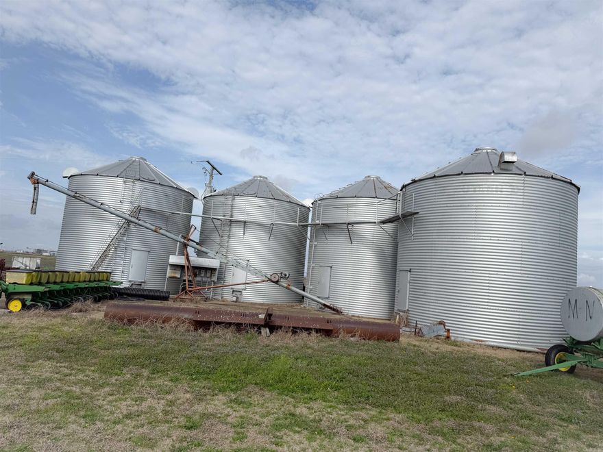 Agricultural property featuring four 12,000 bushel grain bins, offering approximately 48,000 bushels of total grain storage capacity, two of the grain bins have drying capabilities. There is also a 90x60 ft shop ideal for equipment storage.