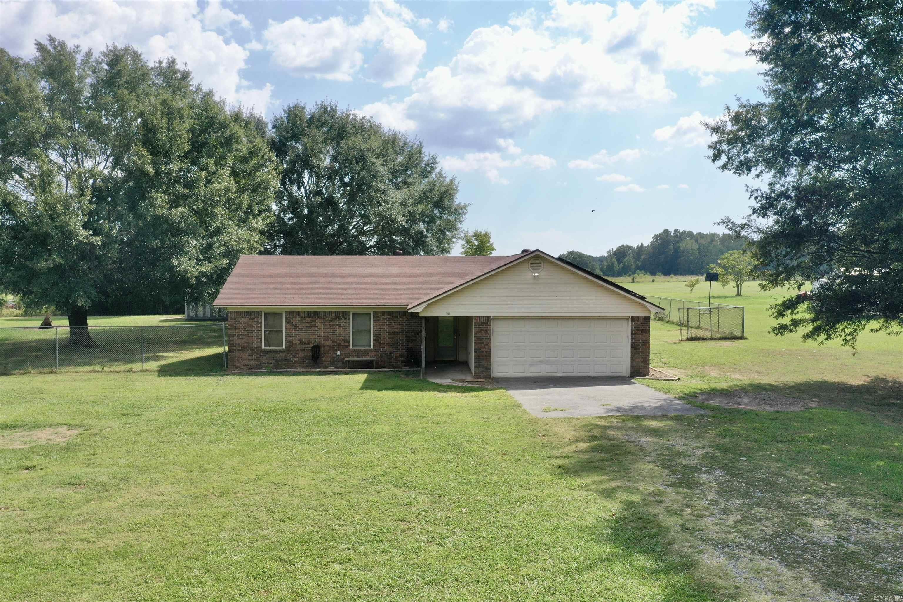 Country living, close to many amenities! This 3 bed, 2 bath, brick home with a slab foundation sits on 2 acres with a 30x38 wired shop (200 AMP, built in 2006) includes a pond and partially fenced. Convenient to US Hwy 64, just 1.5 miles off of the Hwy on a paved road. All electric home with solar panels. Roof is less than 5 years old, new HVAC in 2024, water heater is approximately 2 years old. Updated tile shower in the primary bathroom.