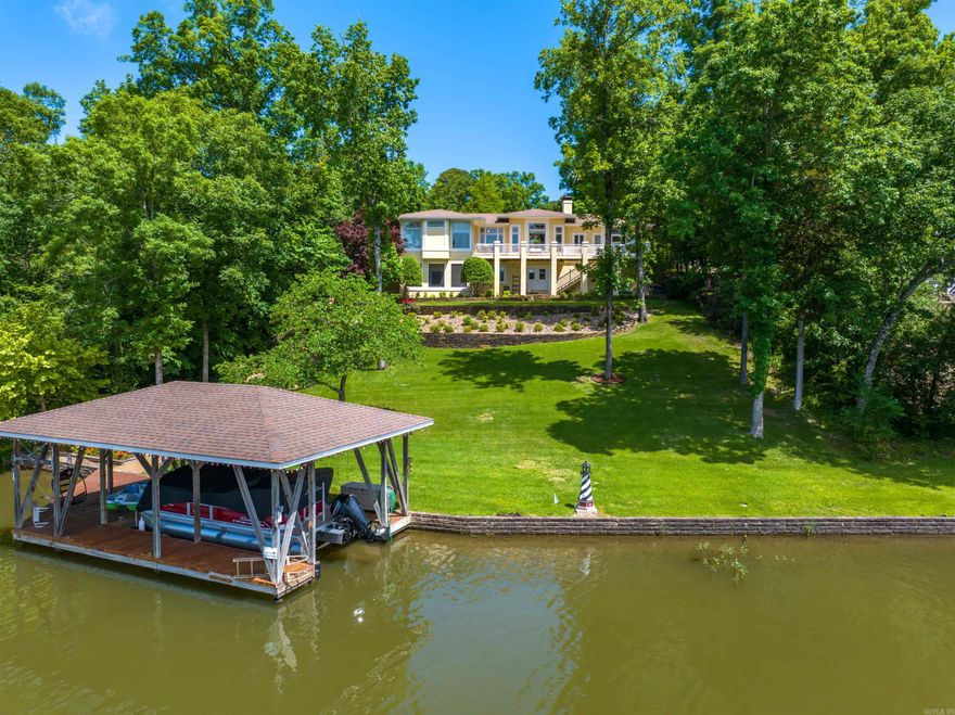 Lk Balboa WATERFRONT! Luxurious living in this quality 4 Bed/3Bath, 3364 (+shop/storage) home! Enjoy the REAL hardwood floors, 14' ceilings, white crown molding, gas fireplace, honeycomb blinds, separate dining room, granite kitchen with gorgeous cherry cabinets, smooth-top range, custom built-ins, and composite deck overlooking the professionally landscaped yard and lake! Primary bedroom offers an adjacent laundry + 5 fixture ensuite. The lower level boasts luxury tile, a recreation room, screened patio, and 4th bed/den + full hall bath. A golf car is included! Ride down the aggregate pathway to the water! The deluxe covered dock with lift has an adjacent swim dock - great for entertaining! New pump from the lake to the irrigation system, 4 zone propane heat/air, 500 gal tank + generator, central vacuum system, built-in speaker system, and huge shop/storage room! 26,000 acre Hot Springs Village boasts 11 lakes and 9 golf courses, with tennis, pickleball, bocce ball, 2 swimming pools, dog park, fitness center, performing arts center, 20+ miles of walking trails, 2 beaches, 2 marinas, clubs/activities/churches and much more!