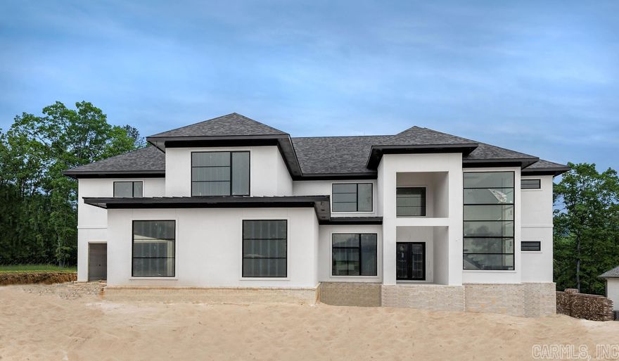 This stunning new build can be found in the gated neighborhood of Orle and offers golf cart access to the Chenal Country Club.  Construction is expected to be completed this summer so if you are looking for a 5 bedroom home, all with private bathrooms this could be the home for you.  Floor to ceiling windows are the setting for the homes stunning floating staircase at the entry. The open great room and kitchen feature a wall of panoramic doors, a gateway to indoor-outdoor living.  The design details don’t disappoint in the primary suite on the main level of the home, with a sitting area, spa bath and oversized walk-in shower.  And if you love closets, this one is amazing!  Need an office or work-out room?  There is a flexible space downstairs in the home that can be used as you wish but certainly spacious enough to accommodate a home office or gym!  Also on the main level of the home is the second bedroom with an ensuite bath.  The other three bedrooms with ensuite baths are located upstairs along with a media room complete with its own wet bar.  Also upstairs is an oversized landing for additional living space and an additional flexible room. Amazing!