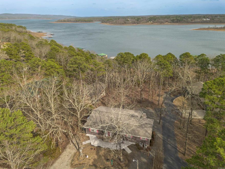 Welcome to 424 Potters Point Road in Higden, a stunning fully furnished lake house situated on Greers Ferry Lake with spectacular views! This spacious 4 bedroom/4.5 bath lake home is 2,610 Sqft on over an half an acre lot!  There is a community dock with two privately owned boat slips which provides exceptional access to the water, making boating and recreation effortless.  Designed with entertaining in mind, this home features an open-concept living & dining area with amazing views of the lake out your windows & from the comfort of your various screened in porches.  Three of the four bedrooms all offer private en-suites & two of these bedrooms are upstairs separate from each other.  The lower level includes an inviting den complete with a pool table, a handicapped accessible bedroom with an outdoor elevator lift, as well as a room with multiple bunk beds.  Enjoy beautiful lake views from the privacy of your screened-in porches offering a serene setting for morning coffee & spectacular evening sunsets. Outdoor amenities include a fire pit gathering area, swingset and a tree swing which further enhance the property’s welcoming lake retreat atmosphere. Short walk to the dock!
