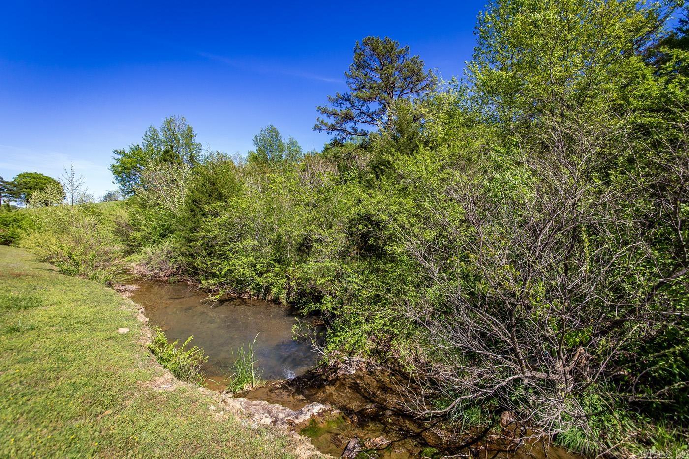 Nice country setting with 2 creeks and 2 lane highway frontage, giving you access to all utilities, including fiber internet. This used to be an old homestead and a boarding house, where people getting off the old M&NA train would stay and it has been said that a septic is on the property (not verified). Approximately 6 out of the 13.04 acres is level and ready for any type of livestock or homesites. This is a great property for you to build a home on or multiple cabins along the creek for vacation rental. Call the Listing Agent for more information and to schedule a showing. Greers Ferry Lake at Fairifeld Bay is just 5 miles away. Enjoy dining, shopping, 90 miles of side by side riding boating, skiing, and more. The Little Red River at Shirley is just 2 miles away where you can kayak, fish, and swim.