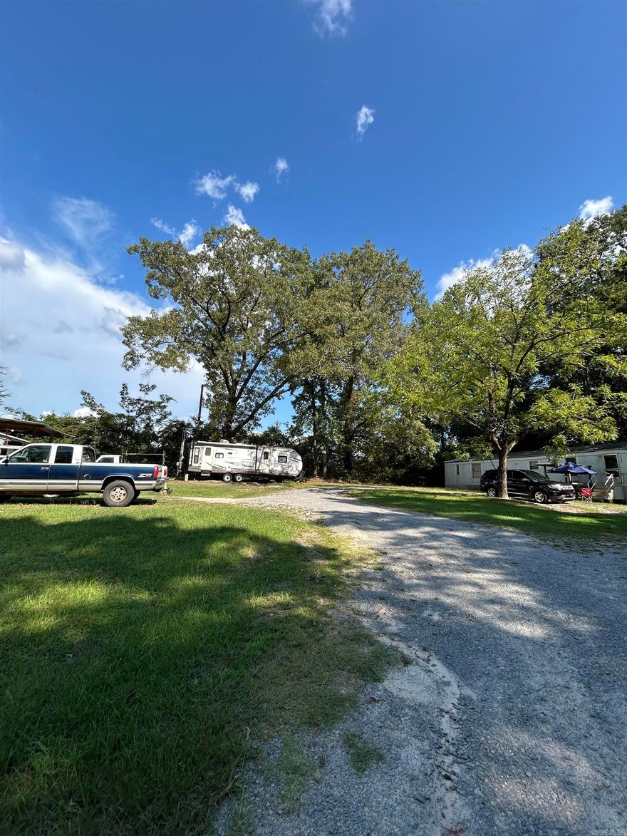 Investors! Well- maintained 2 bed/ 1 bath home situated on nearly 2 acres in a desirable area of town. The hardwood floors were refinished 2 years ago as well as new interior and exterior paint. HVAC system replaced 5 years ago. The home features a large, fenced backyard. Behind the home are 3 mobile home lots; mobile homes do not convey with the sale. Tenants own their homes and rent the lots. One lot currently has an RV owned by the seller that generates rental income and will be removed prior to closing, leaving one vacant lot. There is additional space on the property to add 2-3 more lots. With its prime location, usable acreage, and development potential, this property offers strong long term value and is an excellent opportunity for investors!