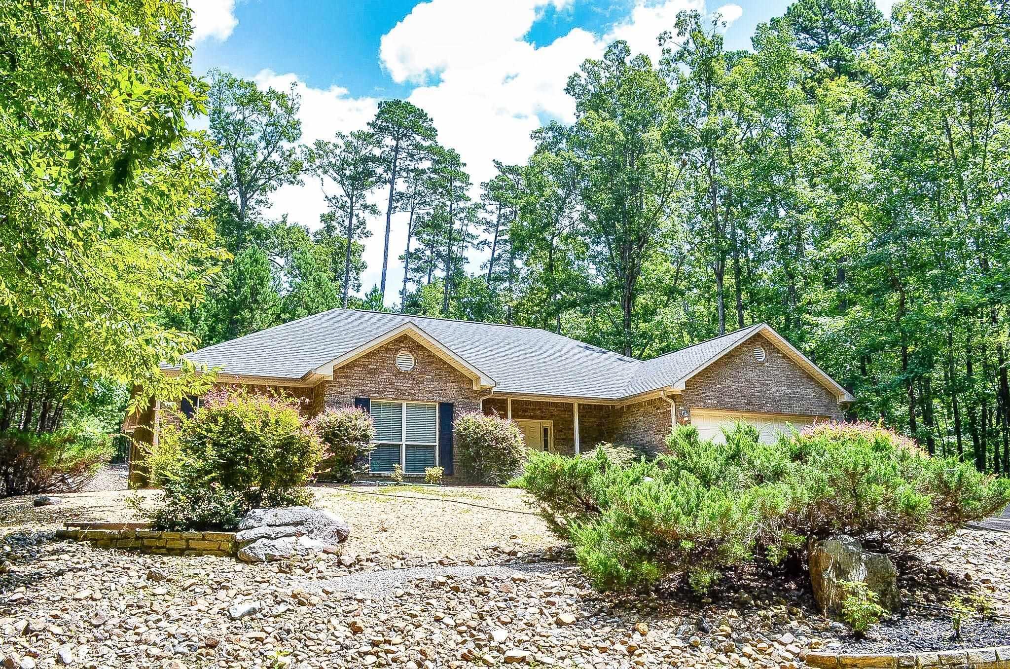 Beautiful 3 bed, 2 bath home on the outskirts of the village. This beautiful home is nicely secluded in the woods of Hot Springs Village, with only a few homes down the road. It's only 8 minutes from the Glazier Peau gate, making it very convenient for making trips to town. This property puts you at a good even distance from all of Hot Springs Village's 8 golf courses and 11 lakes, making it a great location. Beautiful backyard views of the forest, complete with a water feature. The entryway is very welcoming and has a nice foyer complete with tile floors and 2 coat closets. High ceilings throughout the home make this house feel very open. This home features a large open living room with plenty of space, including a very cozy fireplace. The Living Room leads in to a nice sized kitchen with an island, as well as dining area. The guest bedrooms are nicely sized each with walk-in closets and large windows, and share a nice sized bathroom. The Primary Bedroom has plenty of space and features an exit door out to the backyard, as well as a bathroom complete with a jacuzzi tub, walk-in shower, double vanity, and walk-in closet. The heat pump in this house is very new, replaced in 2021.