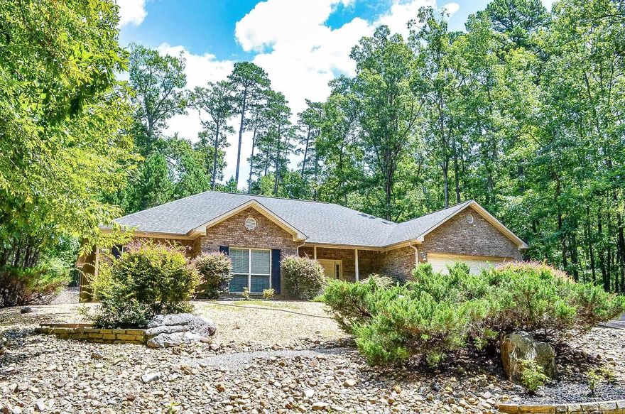 Beautiful 3 bed, 2 bath home on the outskirts of the village. This beautiful home is nicely secluded in the woods of Hot Springs Village, with only a few homes down the road. It's only 8 minutes from the Glazier Peau gate, making it very convenient for making trips to town. This property puts you at a good even distance from all of Hot Springs Village's 8 golf courses and 11 lakes, making it a great location. Beautiful backyard views of the forest, complete with a water feature. The entryway is very welcoming and has a nice foyer complete with tile floors and 2 coat closets. High ceilings throughout the home make this house feel very open. This home features a large open living room with plenty of space, including a very cozy fireplace. The Living Room leads in to a nice sized kitchen with an island, as well as dining area. The guest bedrooms are nicely sized each with walk-in closets and large windows, and share a nice sized bathroom. The Primary Bedroom has plenty of space and features an exit door out to the backyard, as well as a bathroom complete with a jacuzzi tub, walk-in shower, double vanity, and walk-in closet. The heat pump in this house is very new, replaced in 2021.