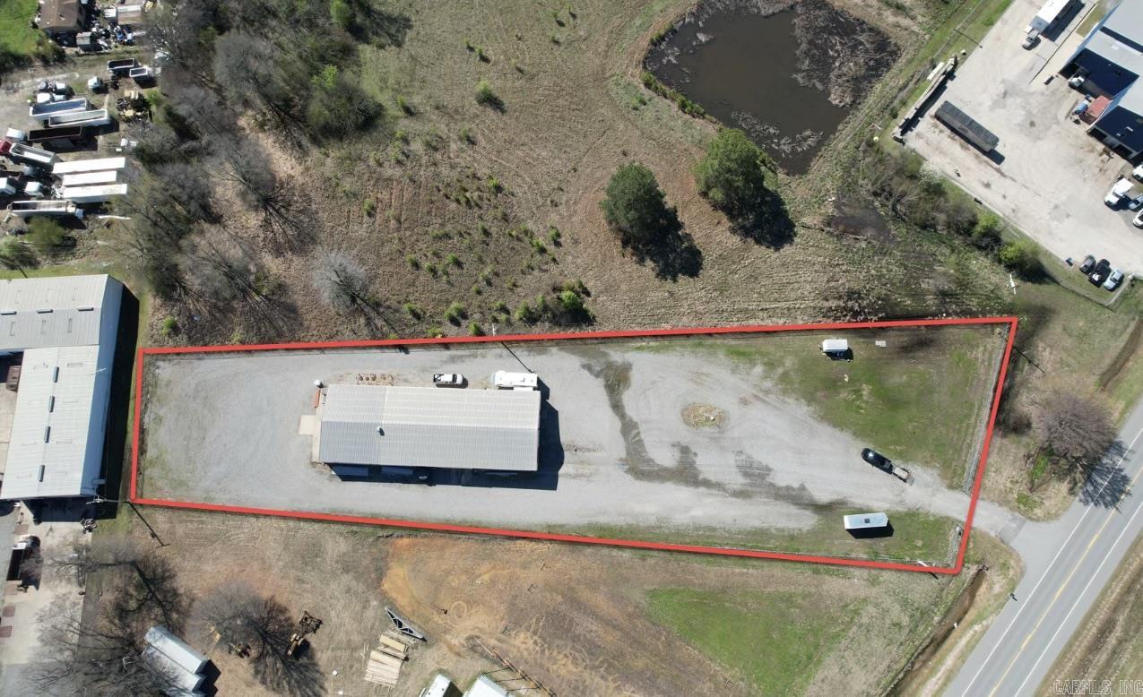 This commercial property offers features ideal for a business seeking versatility and visibility. Situated within the city limits of Searcy and minutes from HWY 67/167, accessibility is an advantage. The office space is complete with a kitchen that is both heated and cooled, a full bathroom and setup for a washer and dryer. Additionally, the property boasts a heat-equipped back bay, making it suitable for various operations. The loading dock at the front facilitates easy handling of goods, while the packed gravel lot ensures durability and ease of access for vehicles. Security is paramount, with the entire property enclosed by a robust fence enhanced with razor wire. The wash bay located in bay number 3 is an excellent feature for businesses that require cleaning facilities. Furthermore, the property includes a septic separation system, promoting efficient waste management. The generous bay doors, measuring 23x12 feet, provide ample space for large equipment and vehicles. The inclusion of 3 phase power in the shop enhances its capability to support heavy-duty machinery, making this property a prime choice for businesses across various industries. Let's go check it out today!