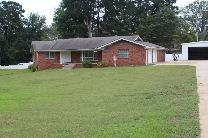 3 Bedroom, 2.5 Baths with approx. 2688 Sq. Ft. of living space located in the heart of Nashville situated on a approx. 1 acre lot.  Large kitchen with the electric range, refrigerator, dishwasher conveying with sell of home.  Family area features massive brick fireplace & beamed ceiling.  Home has knotty pine walls & ceilings.  Central A/C & Heat.  Covered patio.  Home has a basement storm shelter.  Property has a 24 x 30 shop (garage) and white vinyl fencing.