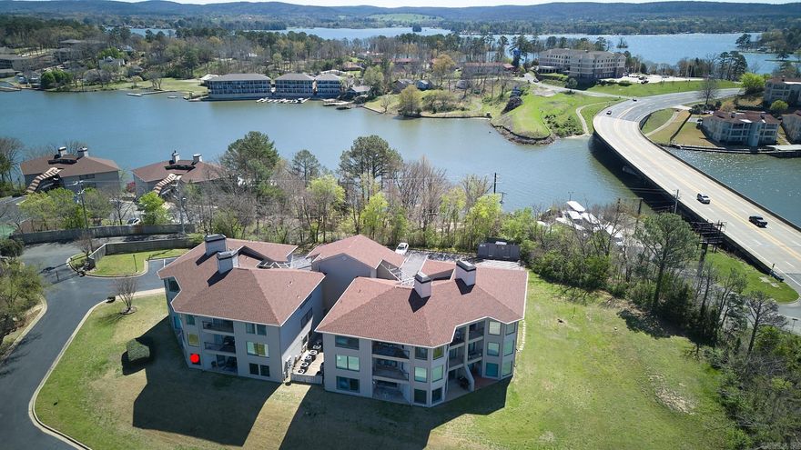 Welcome to your lakeside sanctuary! This ground-level condo on the picturesque shores of Lake Hamilton offers the perfect blend of comfort & adventure. Whether you're yearning for a peaceful retreat or an exhilarating getaway, this property promises to exceed your expectations. Fully furnished and thoughtfully stocked w/everything you need, from plush linens to essential cleaning supplies, this turnkey short-term rental investment is primed and ready to welcome guests w/2 bedrooms & twin bunks in the hallway. No steps to navigate so accessibility is effortless, ensuring that everyone can enjoy the splendors of lakeside living. And with your very own boat slip equipped with a lift, embarking on aquatic adventures is as easy as stepping out your front door. Cruise the sparkling waters, fish to your heart's content, the choice is your with your very own boat slip equipped with a lift. Take a refreshing dip in the inviting pool, perfect your serve on the tennis courts, or simply stroll through the lush grounds and savor the serenity of your surroundings. Two covered patios invite you to relax and unwind, enjoying the lake views.