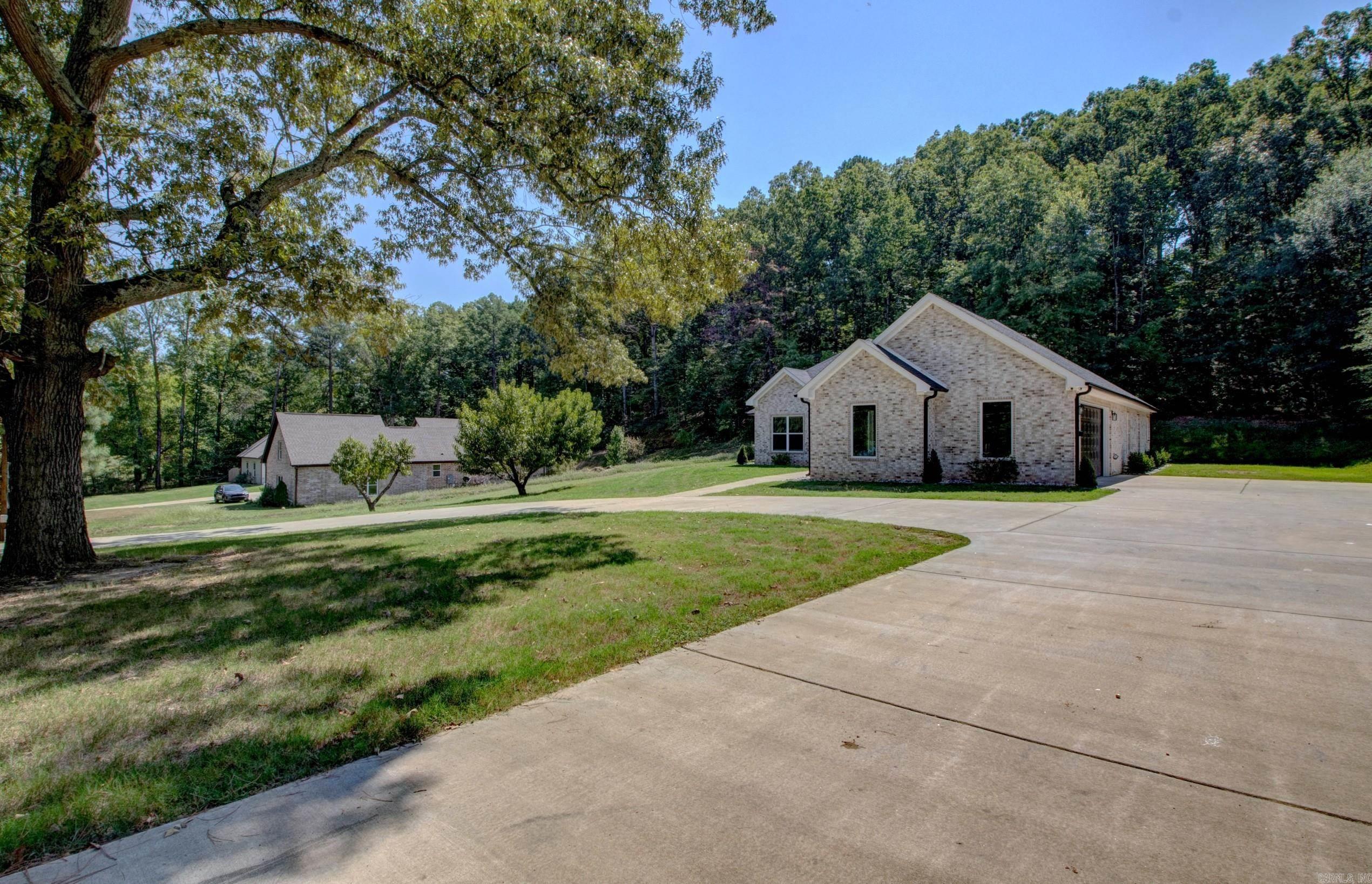 Introducing this exceptional custom-built home, now available in the Bryant school district. This property luxurious features, all situated on over an acre of land. Walk in through the beautiful wooden double doors, being greeted by a spacious foyer that opens into an open-concept living area. This space boasts 11-foot ceilings with wood beams, large windows that flood the home with natural light, and a stylish electric fireplace. The kitchen is a chef's dream, featuring quartz countertops, a custom tile backsplash, a large island, a spacious pantry, and sleek matte black cabinets and fixtures. The primary suite with 13-foot tray ceilings and a spa-like primary bathroom. This includes a fully tiled shower, a corner Jacuzzi tub, and custom-built walk-in closets for both. One of the closets is thoughtfully designed to double as a SAFE ROOM. Two more bedrooms and a flex space or office area and its own dedicated laundry room. Finally, the outdoor living space is enhanced by a covered back patio featuring a beautifully stained tongue and groove wood ceiling, perfect for relaxation or entertaining guests. Don't miss out, Schedule your tour TODAY!