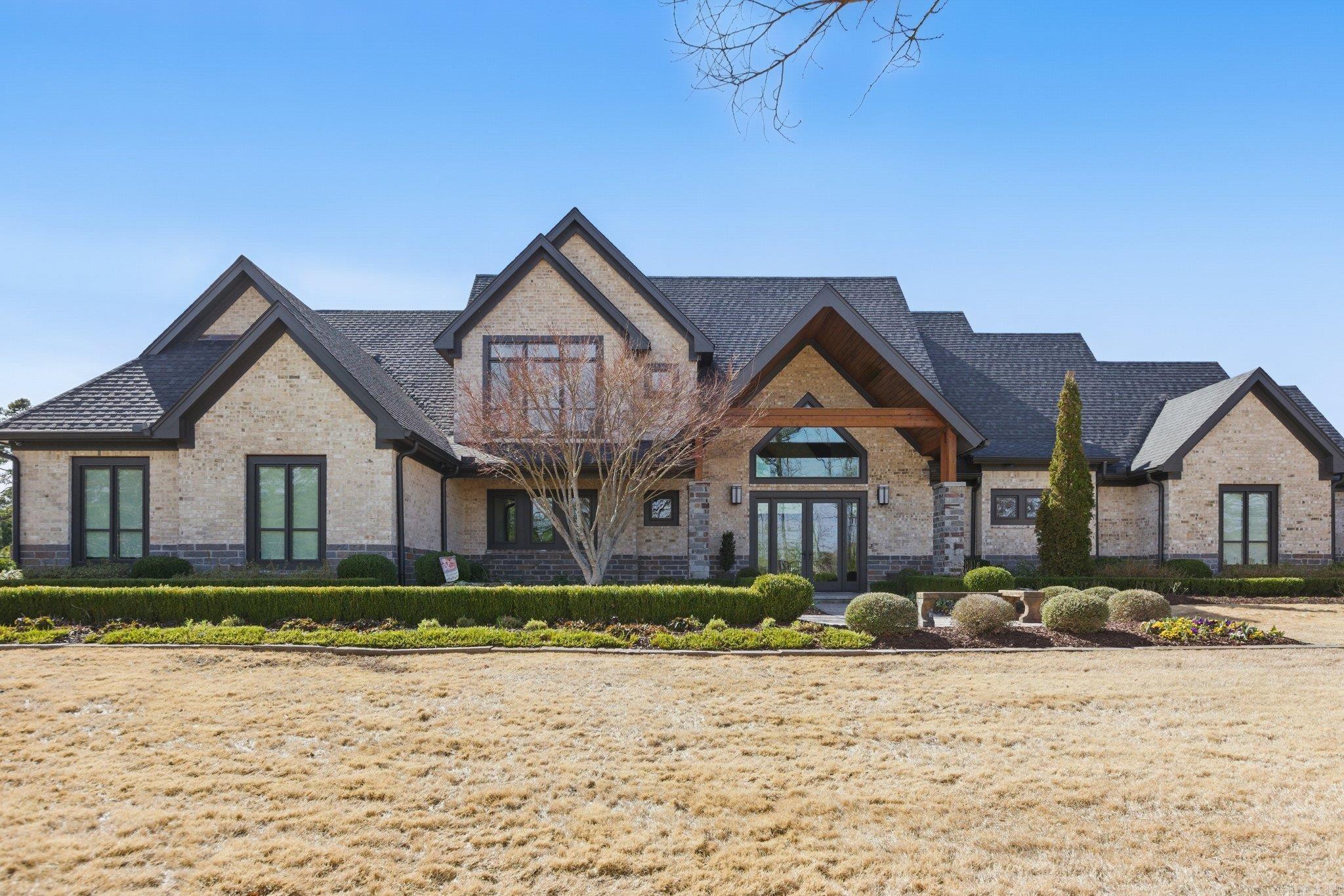 Step inside this one-of-a-kind masterpiece. As you enter, you'll be greeted by a stunning view of the pool, overlooking the wooded terrain and Lake Maumelle. The open foyer welcomes you with a vaulted, jagged wood ceiling and a custom-designed staircase with glass walls. Equipped with Savant technologies this house is a must see. Kitchen has Thermador appliances, a double oven, a Sub-Zero fridge/freezer unit, a crushed ice machine, quartz counters, a walk-in pantry, and a glassed wine room w/ a wine fridge and wet bar. Enjoy two main living areas: one perfect for cocktails overlooking the pool & lake, and a cozy den with a fireplace for relaxing w/ a book. Tile flooring extends throughout the home, and all windows are tinted for UVA sun protection and equipped with Hunter Douglas electric shades with personalized automation. Additional features include a water filtration system, dehumidifying HVACs w/ multi-zone controls, tankless gas water heaters with continuous hot water flow, a Generac generator, and a tornado-safe roof. Step outside to a private setting with estate landscaping, a pool and spa, an outdoor kitchen, an automated mosquito misting system, speakers, and cameras.
