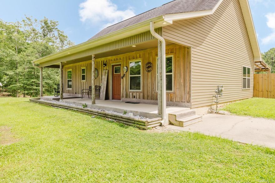 Beautiful home on 5.32 peaceful acres! Open floor plan with a spacious kitchen that flows seamlessly into the living area, complete with beautiful stained concrete floors and a cozy gas-burning stove. Natural wood details throughout including accent walls, doors, trim, and casings—add warmth and style.The main-level primary suite offers a walk-in shower, tub, large walk-in closet, and private access to a patio overlooking the gorgeous acreage. A separate half bath and laundry room on the main floor add convenience. The kitchen boasts stainless steel appliances, a walk-in pantry, and a window over the sink with views of the picturesque acreage—ideal for entertaining and everyday living. Upstairs you will find two additional bedrooms, a full bath, and two expansive attic storage areas. Enjoy outdoor living with a covered back patio off of the kitchen and a spacious front porch featuring cypress board and batten. Located in Bauxite School District with quick access to Highway 35 and I-30 close to town, yet perfectly tucked away for that peaceful, country feel. Large 2 car carport with nice storage room. Plenty of acreage to build a shop, plant your dream garden or more!