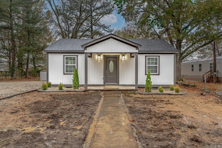 Welcome to the market 207 Perch in Harrisburg, Arkansas. This fully renovated 2-bedroom, 1-bath bungalow with 1,070 sq ft offers new vinyl plank flooring throughout, fresh interior and exterior paint, new cabinets, new countertops, and appliances. The kitchen has a window over the sink, a new LG stainless steel refrigerator, new dishwasher, new range and a new built-in microwave. The bathroom includes a custom porcelain hex tile shower with gold trim and gold fixtures. The living room is spacious with natural light, custom crown molding, and a stylish oval glass front door. Every room has been thoughtfully updated, including new doors, lighting, and hardware. Separate laundry room. Major systems—roof, HVAC, windows—are all brand new. Outside, enjoy a new deck and patio, updated landscaping, and mature trees. This home is move-in ready with custom touches throughout. Call today to schedule your tour!