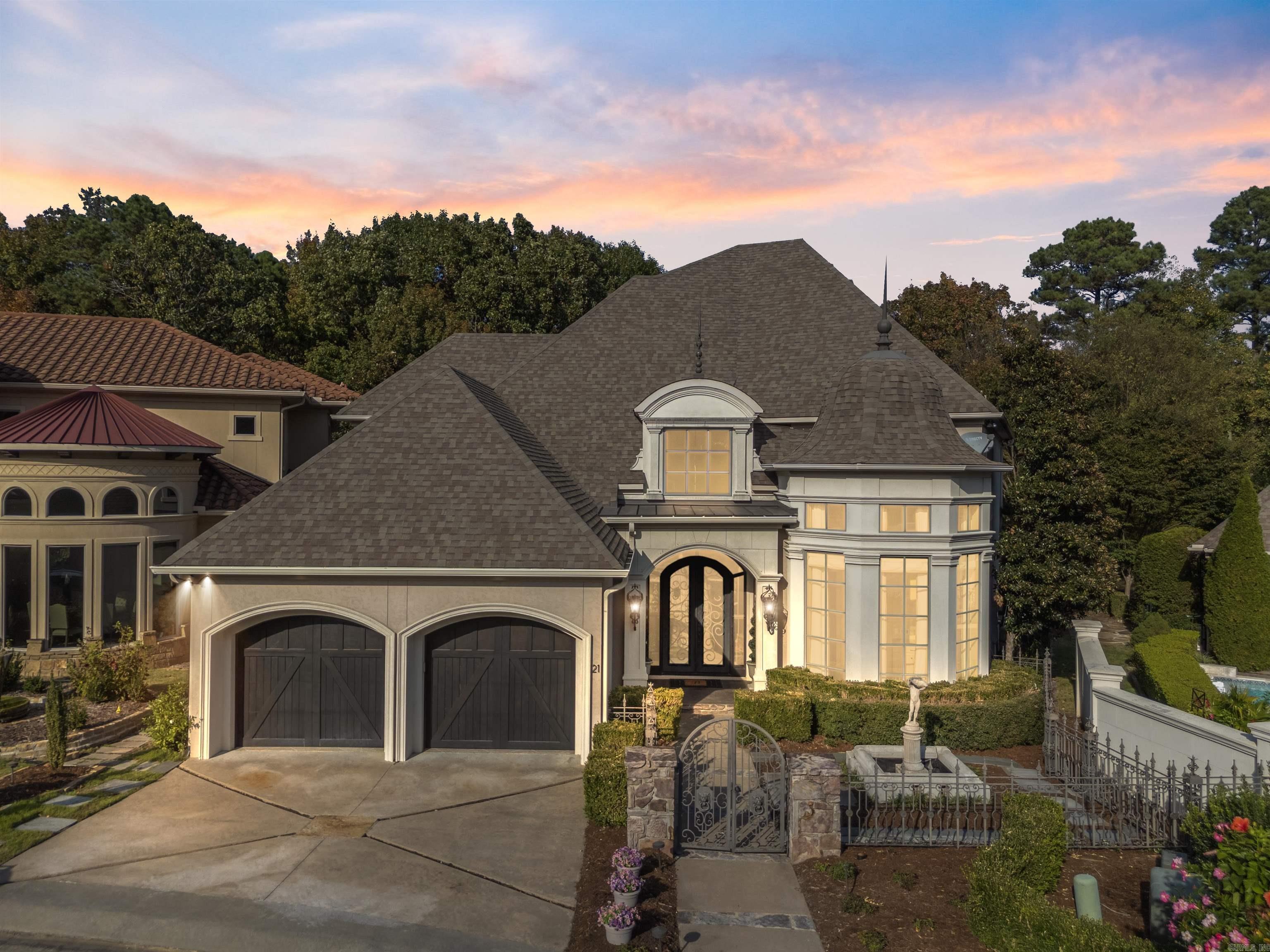 Welcome to an exceptional custom home in the gated community of Hickory Grove built as the Arkansas Symphony Designer Home. This residence exudes elegance from the moment you enter through custom iron doors into the grand two-story foyer, where marble floors and exquisite details set the tone for the entire home. Off the foyer, you’ll find a uniquely designed rotunda-shaped office with an impressive closet featuring cabinetry for refined organization. The expansive great room boasts 12ft ceilings, a fireplace with gas logs, and a well-appointed wet bar-ideal for entertaining. Open to the great room, the chef's kitchen is equipped with premium Viking appliances and abundant cabinetry, offering a sophisticated space for culinary pursuits. The dining room overlooks a captivating backyard oasis, with an in-ground spa and koi pond. The main-level primary suite serves as a private retreat with a luxurious bathroom and a spacious closet featuring built-in cabinetry. A private den is complete with a hidden audio-visual closet and a ceiling adorned with a custom hand-painted mural. Upstairs offers a media room, three bedrooms and two bathrooms. The POA cares for lawn car plus more.