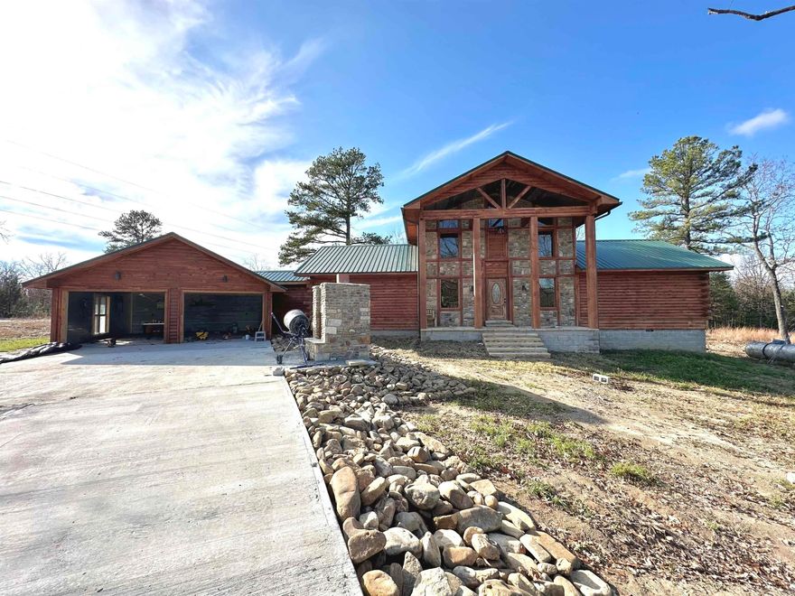 Rustic with all the modern perks! This brand new 2 bed/2 bath custom built log home sits on 1.94 acres joining the Corp of Engineers and less than 5 minutes from Norfork Lake, the Norfork River, the White River and fine dining favored by locals. Upon entering, the living area sets the rustic tone with a beautiful custom staircase that leads to a flex space with a private deck. The kitchen offers tons of custom cabinetry, an eat-in bar, upgraded appliances, custom stone countertops and a farmhouse sink. Just off the kitchen is a large deck for entertaining. The master bedroom offers a large walk-in closet, private bath with tile floors, double vanities and a gas fireplace with seasonal lake views. A large second bedroom shares the hall bath with guests. Finished out with metal walls, the double garage offers plenty of extra storage or a place for entertainment near a custom built outdoor stone fireplace. Whether you're in the market for a full time residence or a short term rental investment opportunity, this property is waiting on you to make it your own.
