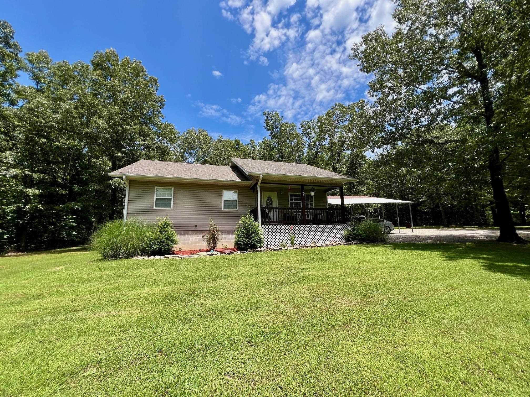 Welcome to your own slice of country charm nestled on just over two acres m/l! This 3-bedroom, 2-bath home offers both comfort and breathing room, ideal for families or those looking to retire in peace. The vaulted ceiling in the living room creates an open, airy feel while allowing plenty of natural light to filter through. The oversized double carport provides ample covered parking or space for weekend projects. Step out to enjoy serene views from the front porch—you might even catch a glimpse of the local wildlife dropping by for a visit. The newly installed heating and cooling system from 2024 means you can relax through every season. The spacious master bedroom adds extra comfort and privacy, perfect for unwinding after a day spent outdoors. The outdoor space is a highlight, whether you're sipping coffee on the porch or picturing a garden, play area, or room for pets to roam. Don’t be surprised if guests say it feels like a mini vacation. This home blends practical features with peaceful surroundings to create a lifestyle worth discovering.