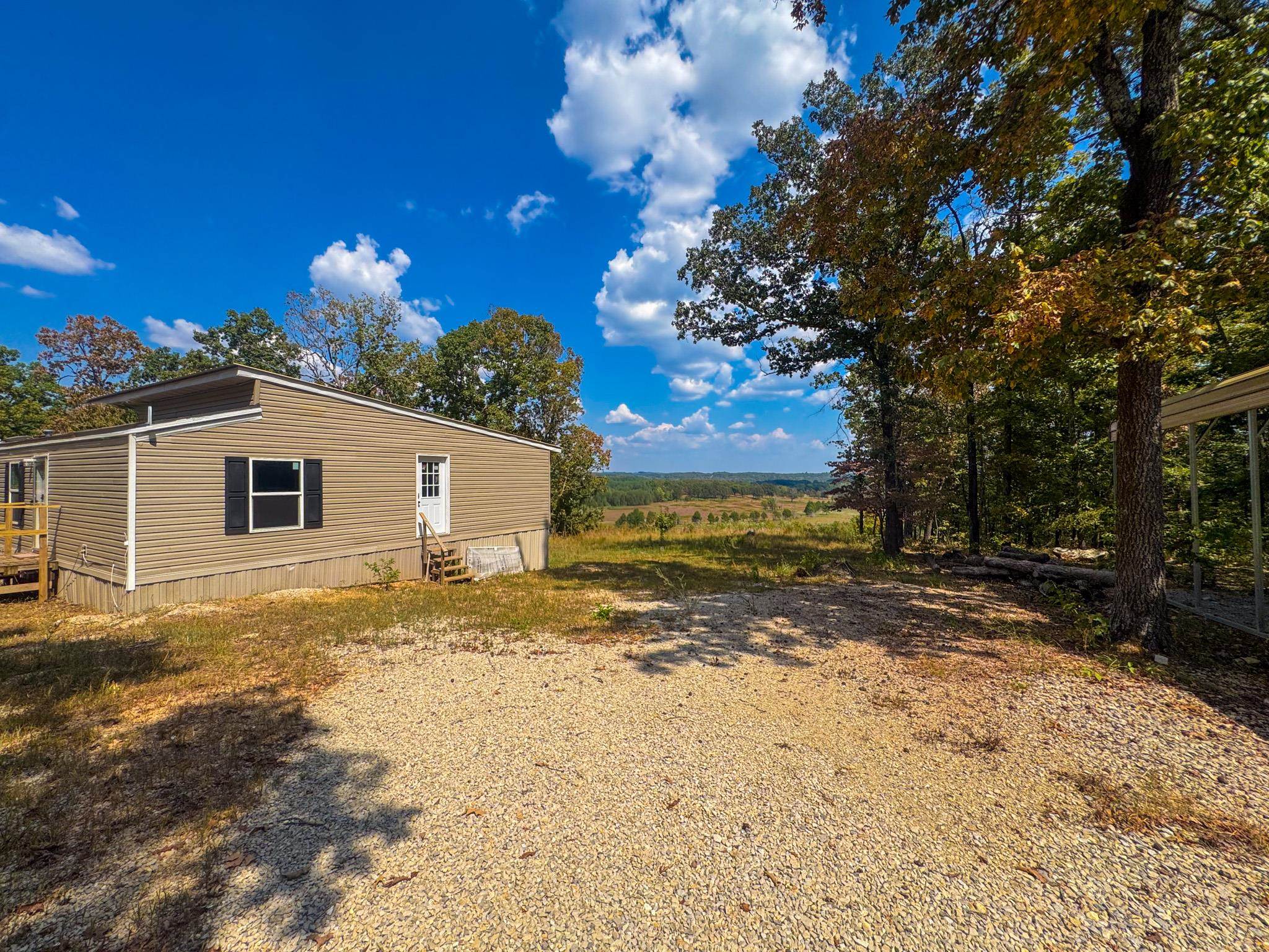 A rare combination of privacy, beauty and opportunity. Nestled down a well-traveled dirt road, this private 10-acre property offers a peaceful wooded setting with a stunning vista view. The land touches the Strawberry River, adding a unique natural feature, though direct access is currently limited. The residence is a 2023 Clayton mobile home with a spacious addition, featuring three bedrooms and two bathrooms. Additional improvements include an RV carport, a storage shed, and a walk-in storm shelter for added safety and convenience. This property combines natural beauty with functional living space, making it ideal for those seeking a quiet retreat or a full-time residence surrounded by nature.