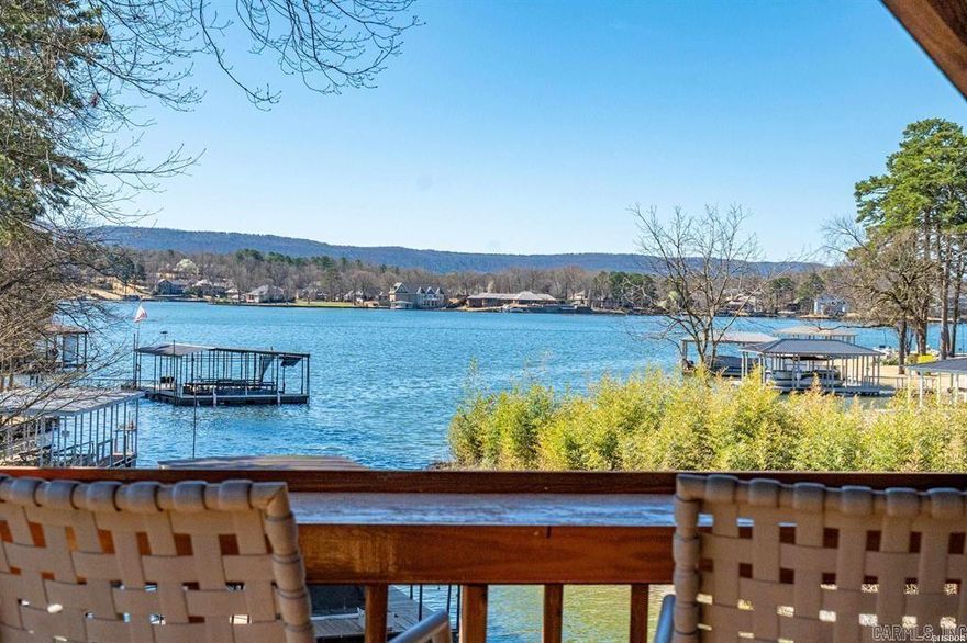 Imagine a charming lake house nestled along the water’s edge that has a spacious covered patio along the entire the back of the house that offers multiple cozy outdoor seating arrangements.  In addition to the covered patio is an additional deck offering both covered and uncovered seating options, all overlooking the lake.  The boat dock is just steps from your deck for ease in getting on the boat to enjoy lake life.   Inside the lake house, the open floor plan seamlessly blends the living room, kitchen, and dining area to allow for ease of conversations.  Multiple large windows across the back of the house flood the space with natural light, offering an uninterrupted view of the water.  The living area features a ceiling with exposed wooden beams, a 2-sided fireplace for both the dining room and living room to enjoy.   The primary suite is a private lakeside retreat, designed for both comfort and luxury. Large windows frame stunning views of the water, allowing natural light to pour in while offering a peaceful ambiance. Whether you're looking for a weekend getaway or a full-time escape, this home is ready to welcome you. Call now before it's gone!