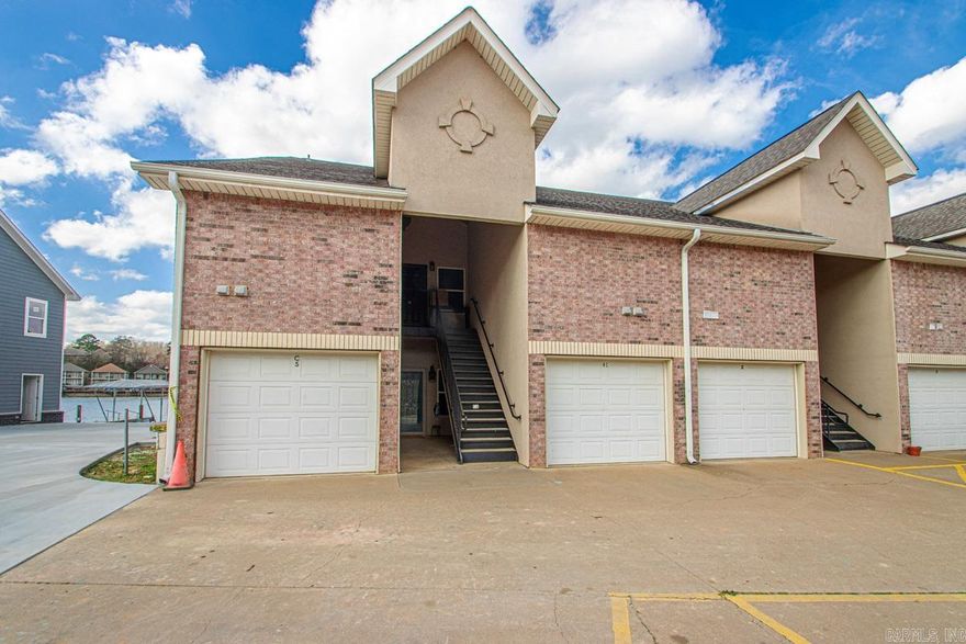 Enjoy the rare combination of space, privacy, & true lakefront living in this 4-bedroom, 3-bath end-unit condo on Lake Hamilton. Offering over 2,700 square feet & an attached garage, this property lives more like a private residence than a typical condo. Tucked along the shoreline, the setting places you just moments from the water, with sweeping lake views & an added sense of seclusion thanks to its end-unit location. Inside, the thoughtfully designed floor plan features two primary suites, two fireplaces, & two private balconies, providing comfortable & flexible living for everyday use or guests. The main-level primary suite & laundry add everyday convenience, while the upper level offers a private retreat with a second suite, kitchenette, & private bath—perfect for visitors or extended stays. Step outside a& enjoy the community boardwalk, or spend a quiet afternoon fishing from the dock just steps away.With nightly rentals permitted at Grand Point, this property also presents strong income potential & long-term value. Whether you’re searching for a primary residence, a weekend lake escape, or an investment opportunity, this exceptional Lake Hamilton condo has so much to offer.