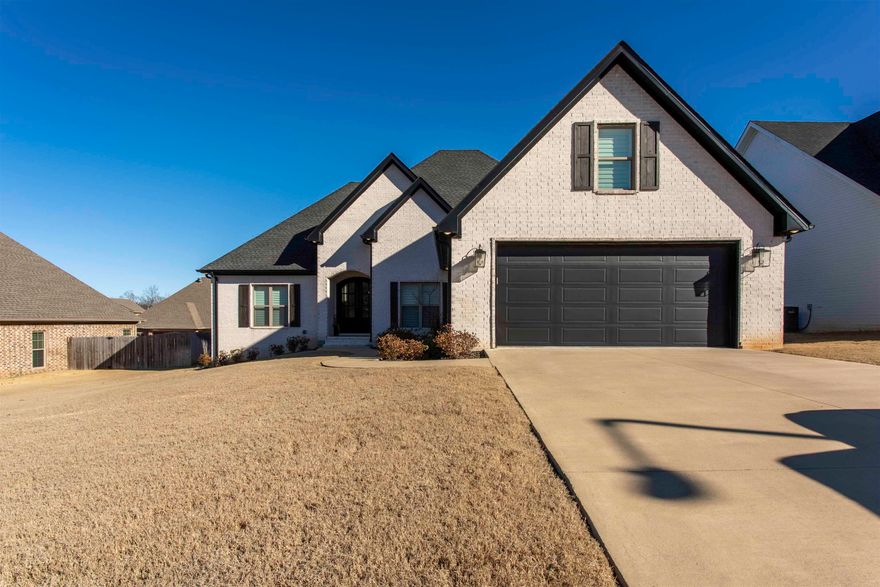 Welcome to 3112 Harrison Hills Drive in the Harrison Hills subdivision of Jonesboro. This well-maintained brick home offers approximately 2,654 square feet and is being marketed as a 4-bedroom, 3.5-bath home. Beautiful plantation shutters are featured throughout, adding a timeless and upscale touch. The main level offers three bedrooms, two full bathrooms, and a half bath, along with an open and split floor plan highlighted by tall ceilings, crown molding, and Pergo TimberCraft flooring with WetProtect Technology in the main living areas. The spacious living room features a custom fireplace with wood beam mantle. The kitchen is well-appointed with white cabinetry, a large center island, stainless steel appliances, pendant lighting, and light stone countertops with soft veining. A dedicated dining space provides an inviting area for everyday use or gatherings. The primary suite is located on the main level, with the additional main-level bedrooms situated on the opposite side of the home, creating a desirable split-bedroom layout. The primary bathroom features a soaking tub, tile walk-in shower with bench and niche, dual vanity with stone countertops, and a large walk-in closet with