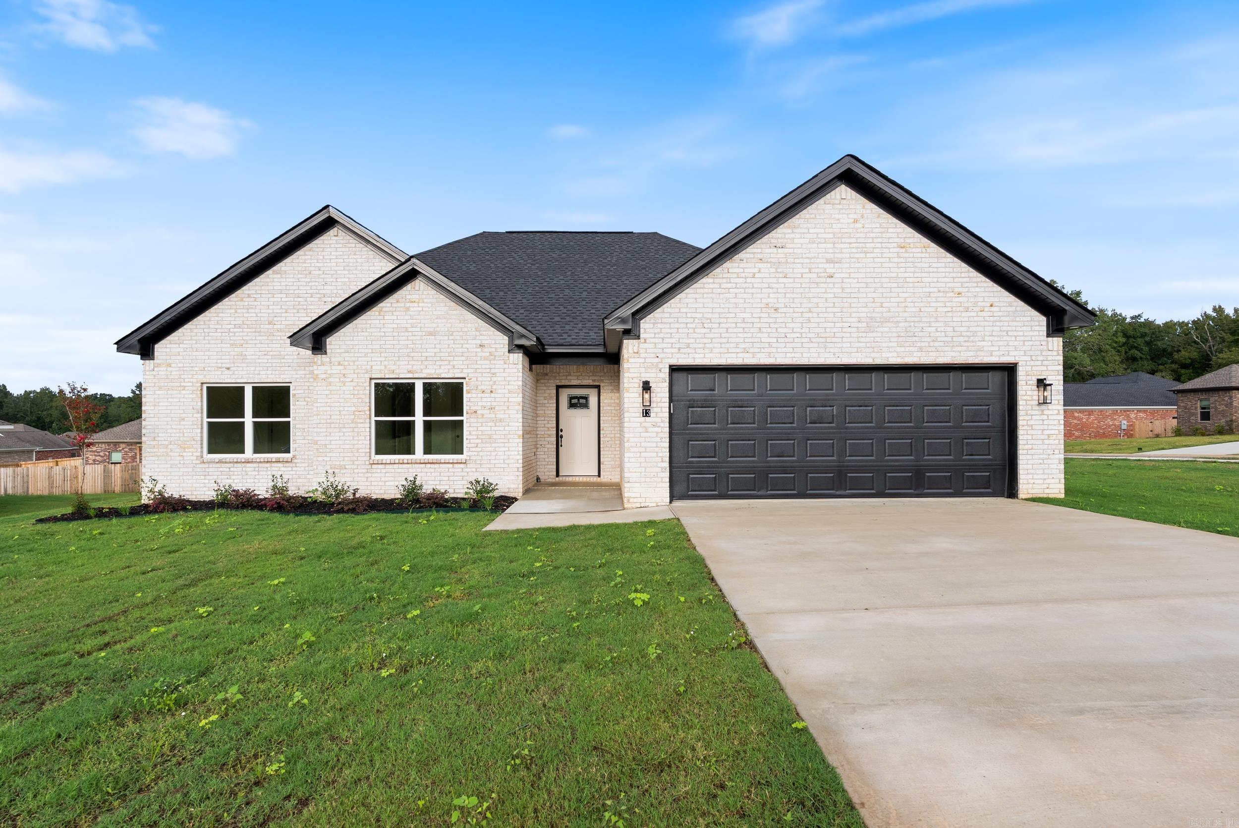 Stunning new all-brick home with striking white brick and black finishes on a corner lot in Lewis Cove Subdivision! Located directly across from Wooster Elementary, this new construction showcases modern style and thoughtful details throughout. Highlights include an electric fireplace with custom trim work, an accent wall in the primary suite, and a spa-inspired bath with a large soaking tub, tiled walk-in shower, and spacious primary closet. The kitchen offers a pantry, while the laundry room features custom cabinetry and built-in lockers for a mudroom area. Additional features include an insulated garage door, covered back patio, and the convenience of fiber internet access. Builder offering a one year builders warranty.