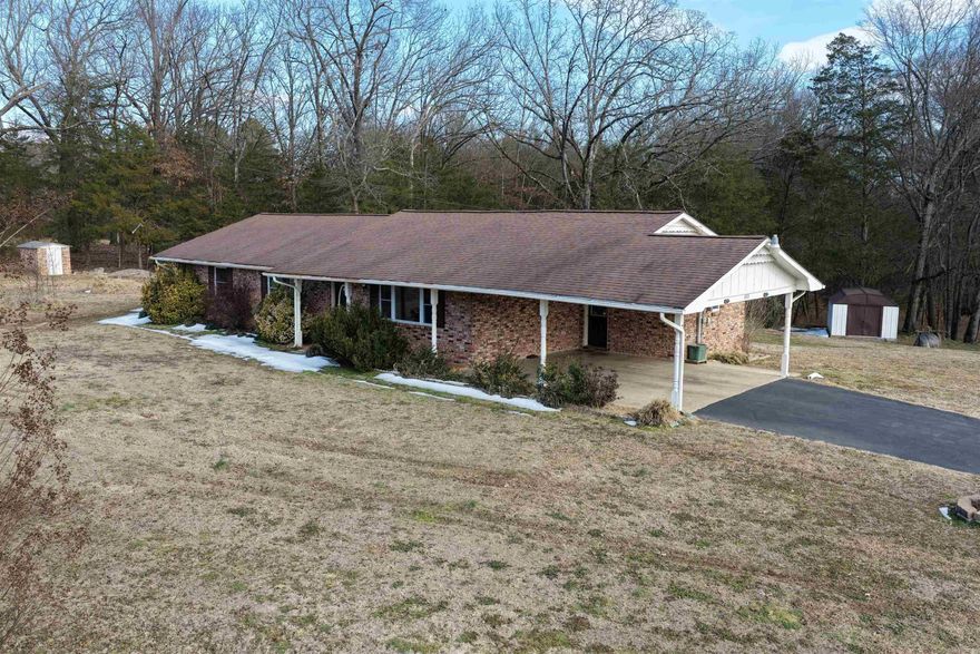 Exceptionally well-maintained single-family home on a spacious 0.80-acre lot in the Clarksville City School District, featuring a rare indoor storm shelter—a standout safety feature seldom found in this area. This 2,113 sq ft masonry home offers 3 bedrooms and 2 full baths with extensive updates throughout.  Major improvements include a new Bryant 4-ton heat pump with duct modifications (2025), fiber optic internet, architectural shingle roof (2017), updated kitchen with custom cabinetry, and remodeled bathrooms with a walk-in shower and glass doors. A large 20x20 sunroom adds versatile living space and houses the interior storm shelter, providing peace of mind during severe weather without leaving the home.  Exterior amenities include a deck, carport, shop with electricity and lean-to, asphalt paving, and a wide lot with pastureland behind for added privacy. Property includes both city water and a well (needs pump) for outdoor use, along with multiple exterior water sources. Convenient south Clarksville location with easy access to downtown