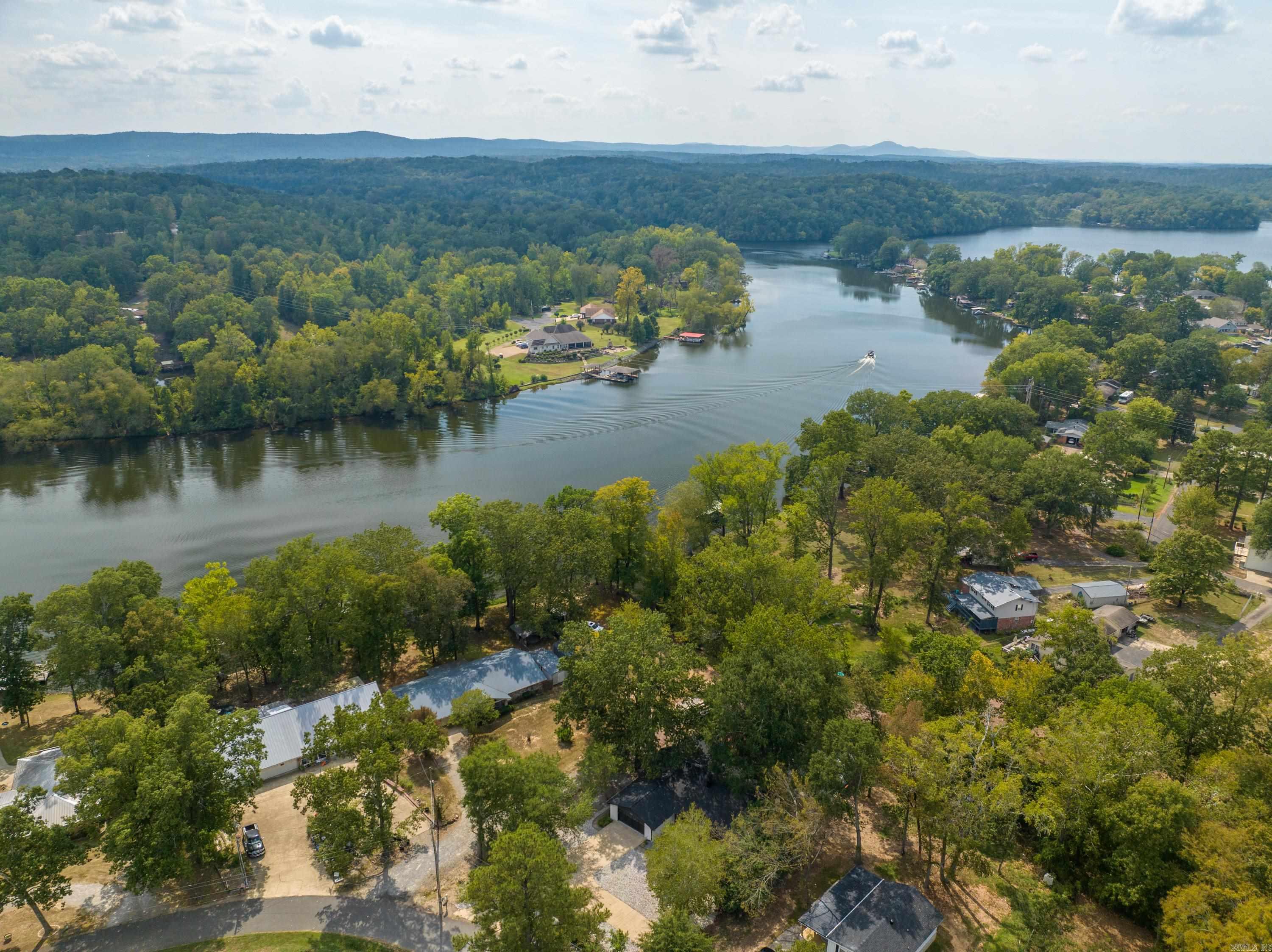 *Lakefront home with covered boat dock!* This beautifully updated home offers lakefront living at its finest, featuring an open concept layout, a covered boat dock, and modern upgrades, including a new roof, HVAC, and state of the art appliances. The neighborhood includes a private boat ramp, adding even more convenience. Enjoy outdoor living with a spacious deck, patio, and a 19x9 storage building, perfect for storing lake toys, kayaks, or outdoor gear. Conveniently located 5 minutes from the MLK bypass, 6 minutes from Lakeside schools, and 10 minutes from Bathouse Row, this property is close to shopping and dining. Currently a short term rental, it's available fully furnished with high end contents. *Entergy approved permit do dredge the lake 2 feet.* Call today to see this turnkey lakefront retreat!