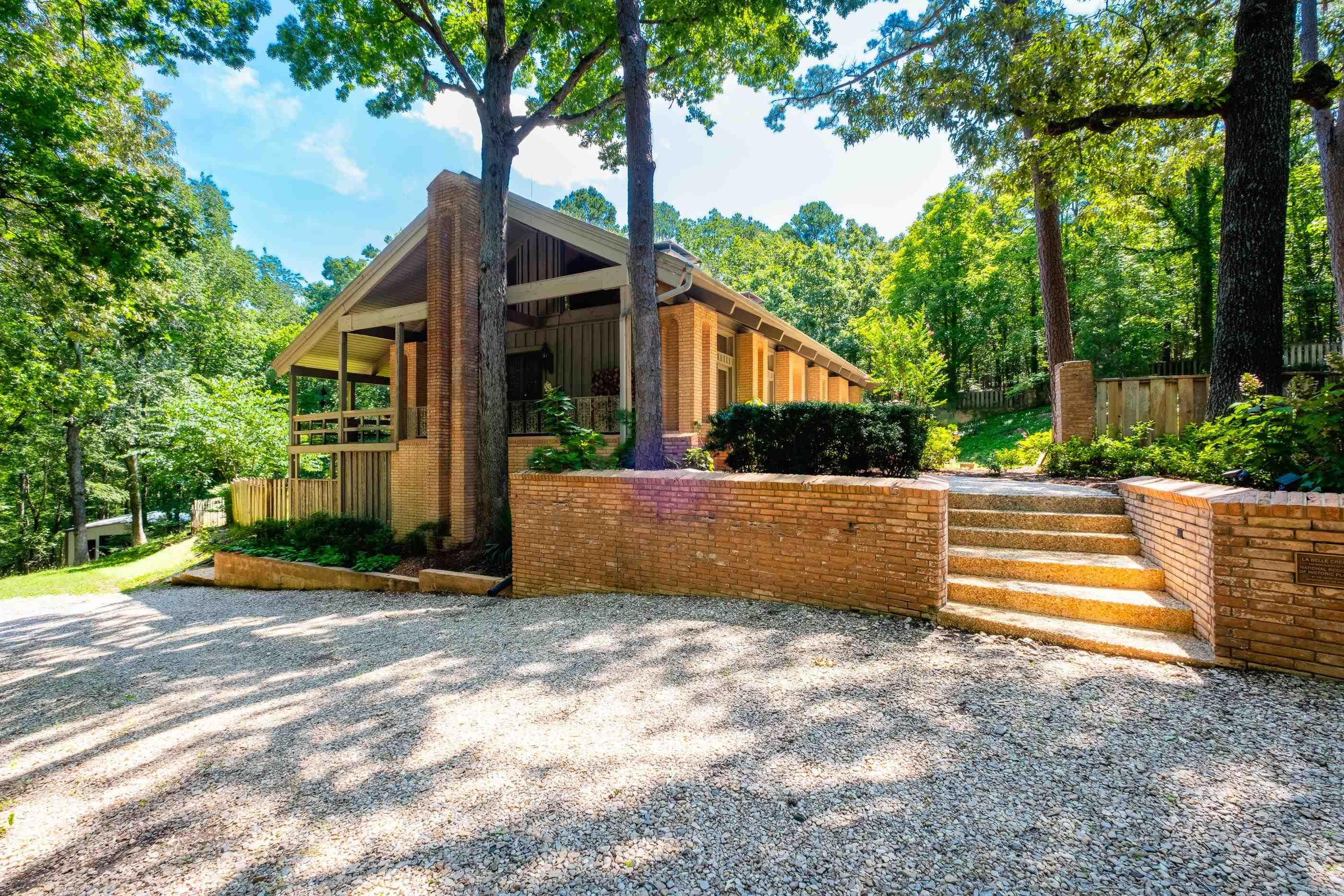 Welcome to āLa Belle Creole,ā "A Beautiful Mixture." Custom built by Richard Redding Stevenson Jr., this one-of-a-kind, private 2.36 acre residence features Saltillo brick imported from Mexico, soaring ceilings with Cypress wood framing and boards, and a wraparound porch. Step inside to be greeted by a tall curved brick wall and elegant wood floors that flow into the living room with a cozy wood-burning fireplace and large windows. The recently added custom cork wall adds warmth and texture to the living room. Past the living room, find the spacious primary suite with a wood-burning fireplace, a large en-suite bath with a sunken tub, walk-in shower, and generous walk-in closet. The kitchen has been tastefully updated with Taj Mahal quartz countertops & backsplash, a Kohler Basin sink, GE Cafe appliances, & a walk-in pantry. Take the spiral staircase down to find a cozy living area, kitchenette, laundry room, 2 bedrooms, 2 bathrooms, & multiple storage spaces. Outdoor living includes an in-ground pool, a large workshop, a detached 3-car covered carport with extra storage, and a circle drive for easy access and parking. New Roof, Water Heater, and HVAC systems. Agents See Remarks
