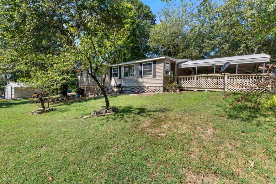 Come see this extremely well maintained home with a newer metal roof (replaced in 2019), new water heater, and new accessible walk in shower. There's covered parking, a nice big yard and even though it's near town - it feels like secluded, wooded retreat.