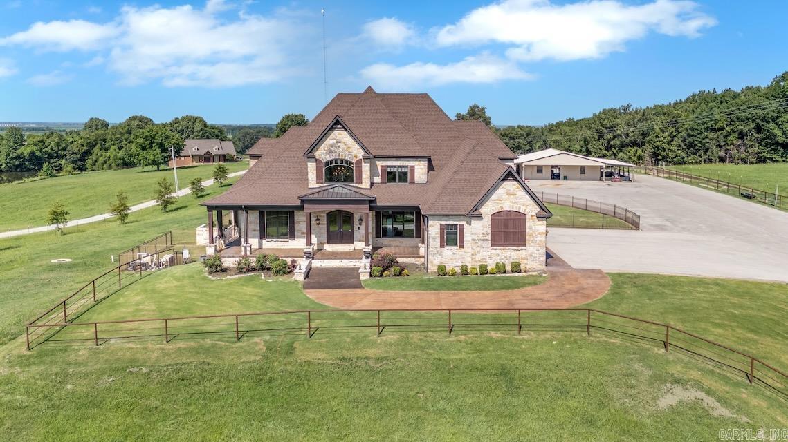 Luxury Ranch Estate with 62+ Acres & Equestrian Facilities. Experience exceptional living on 62.88 acres designed for both elegance and functionality. Behind a gated, fully automated entry, this 7,350 sq ft, 4-bedroom, 4.5-bath residence blends timeless craftsmanship with modern conveniences and topped off with a new roof in 2025. The interior features custom woodwork, stone accents, pet spa & grooming room, and expansive windows that frame picturesque views of manicured pastures and stocked ponds. The gourmet kitchen is equipped with top-of-the-line appliances, dual islands, and a stone backsplash, making it ideal for both everyday living and entertaining. A finished basement, wood/gas fireplace, smart home security with cameras and visitor alerts, and seamless access to the saltwater pool and hot tub elevate the experience. The owner's suite offers a spa-inspired bath and private office, while three additional ensuite bedrooms ensure guest comfort. Peace of mind comes from two built-in safe rooms, a Kohler 60 kW generator, dual 150-gallon water heaters with pressure pump, and gas emergency heat backed by a 1,000-gallon craft propane tank.