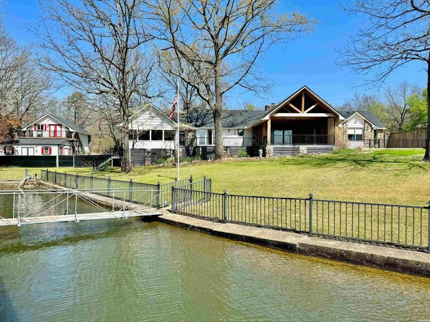 Very rare find on Lake Hamilton! Situated on two level lake lots, this one acre property boasts an impressive 200 feet of lake frontage, providing stunning views and ample space for outdoor enjoyment.  The fully remodeled one-level main home consists of 3 bedrooms & 3 bathrooms. Features include a brand new roof, vaulted ceilings, two rock fireplaces, a huge master suite equipped with a separate study and screened in porch.  The newly built back deck provides amazing views of the lake and is adorned with rustic wood beams and composite decking, perfect for outdoor entertaining.  Attached to the main home is a two car carport; however, an additional highlight of this property is the detached garage with a 1BR/1BA guest apartment above.  The garage, along with the separate storage building, provide ample storage for the owner and privacy for guests. The back yard is fenced, and the oversized boat dock will accommodate a large boat. With its blend of modern luxury and natural beauty, this lakeside retreat offers an idyllic escape for those seeking the ultimate in lakeside living on Lake Hamilton.