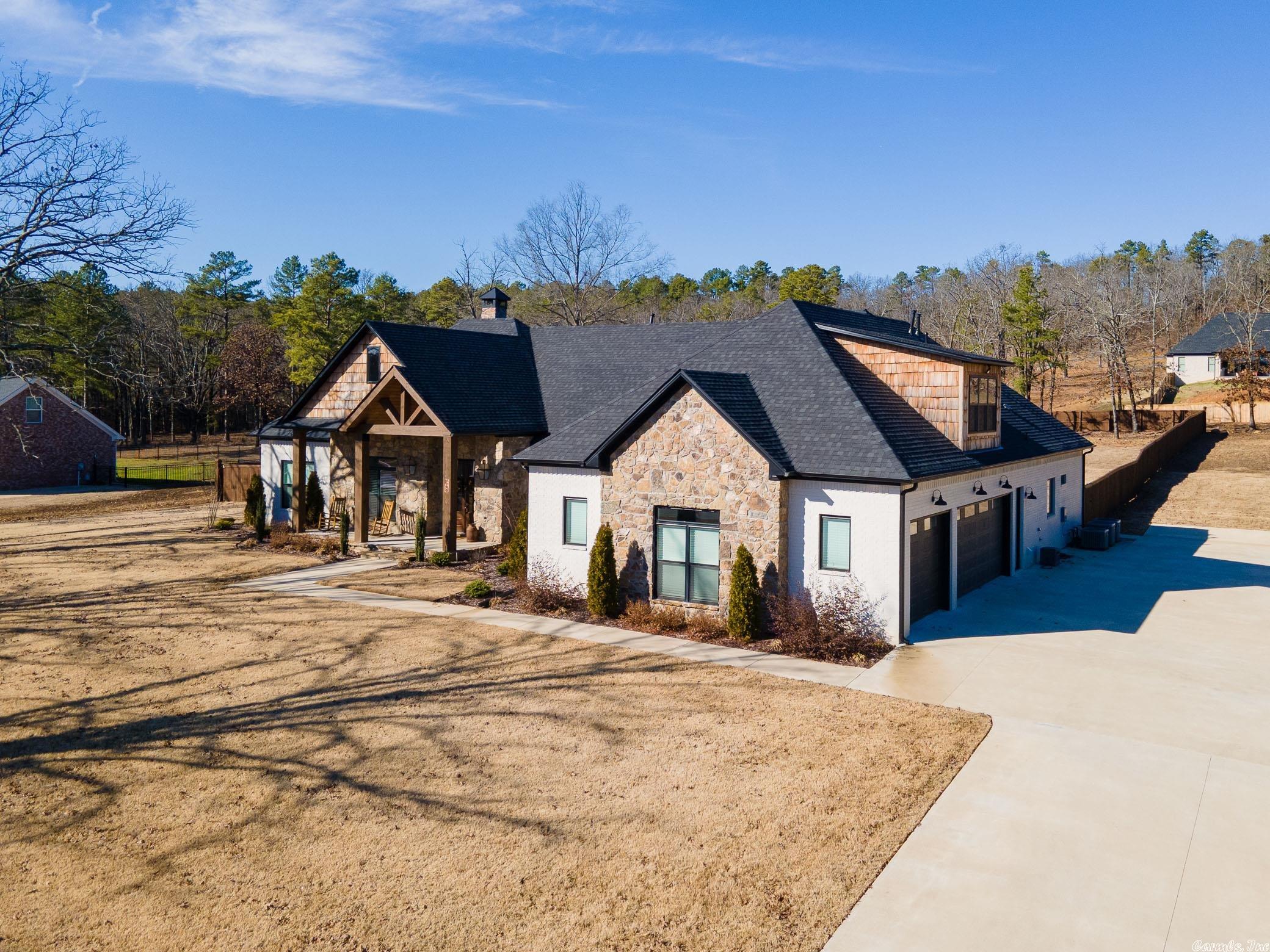 This stunning home in the gated N Woods Estates is the perfect design for family living and entertaining. The hand scraped hardwood floors, vaulted 10ft ceilings and countless high-end finishes give a beautiful flow throughout the 3 bed/3.5 bath home. The master bath is equipped with double vanities, custom walk-in shower and jacuzzi tub. Entertaining is a dream between the large bonus room upstairs and the backyard that contains a covered patio and inground saltwater pool. Additional features include: a tankless gas water heater, gas starter fireplace, Bevolo front porch gas lanterns, Grants custom cabinets and 8ft doors throughout and oversized three car garage.
