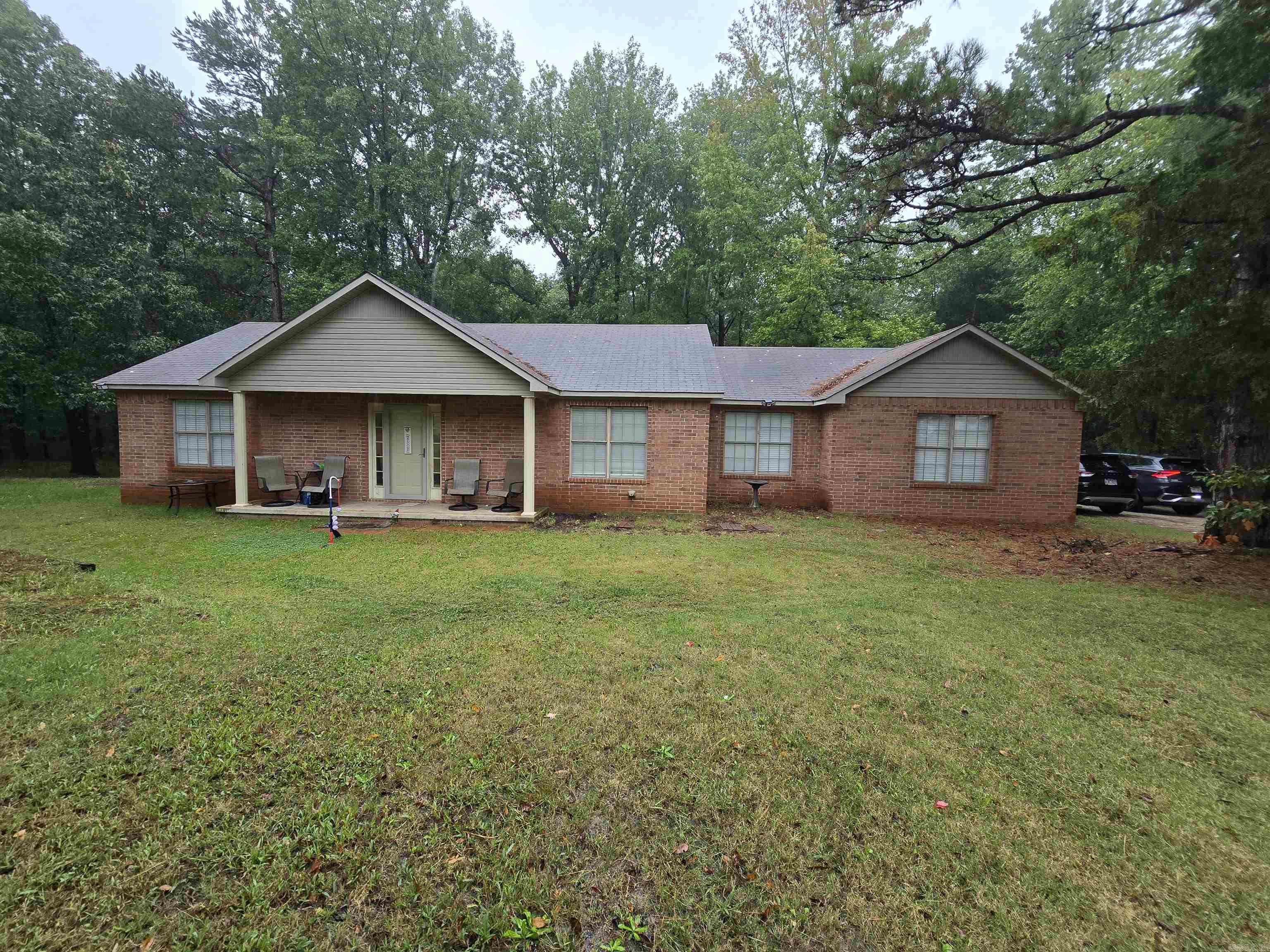 Set on 2.5± acres (mostly wooded) this brick home with side entry 2-car garage, offers peaceful country living with plenty of privacy. Central electric heating and cooling provide comfort throughout the year. The vaulted great room flows into a combined kitchen and dining area, offering ample space for entertaining. The galley kitchen includes a work and storage island, and just off the kitchen is a flex space that could serve as an office, reading nook, or study area. There are four generously sized bedrooms. The primary bedroom includes an en-suite bath and is located at one end of the home. At the opposite end are two more bedrooms and an unfinished mother-in-law suite with a half bath. The large lot offers many opportunities for outdoor living, gardening, or simply enjoying nature. This property is perfect for anyone looking for a private rural setting without sacrificing comfort or function.