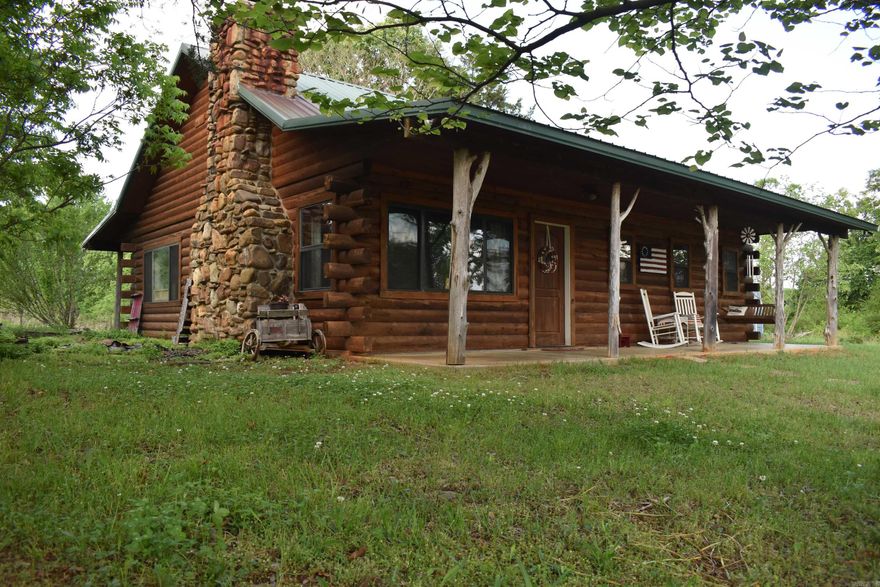 If you have been looking for privacy and seclusion, but don’t want the maintenance that comes with large acreage, you need to take a look at this Beautiful Log Cabin and acreage! The 10 +/- acres is located off of a quiet county road with very few neighbors. The 1250 +/- Square foot log cabin is just that, a true log cabin finished with all of the cozy amenities that you would expect, like the rock fireplace, front and back porches, and loft overlooking the living area. The cabin speaks for itself, with beautiful rustic finishes that perfectly fit the space. Outside there are flower beds and garden areas, barns, outbuildings, and even a treehouse with a slide.  The 10 +/- acres is truly special as well, with no neighbors in sight, and an amount of privacy and seclusion that is rare to find on a tract this size. The land is mostly open, with rows of timber around the property boundary and scattered across the acreage. The Ouachita National Forest is just 1/4 mile away, giving access to hundreds of thousands of acres of public land with great hunting opportunities. All of this is located just 10 miles from Waldron, AR.