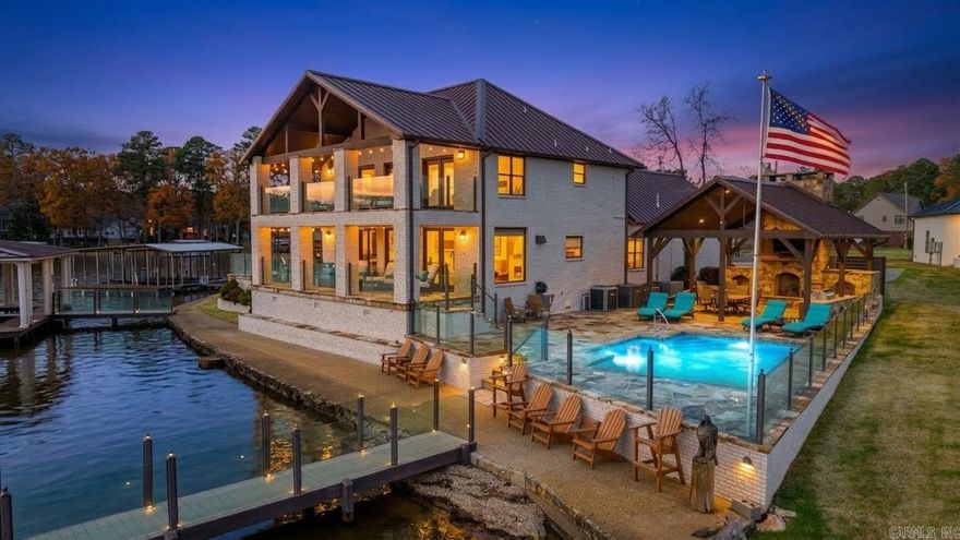 Welcome to your lakefront dream home on the shores of Lake Hamilton Arkansas. This stunning 3,419 square foot home offers 4 spacious bedrooms, 3.5 baths with high-end updates throughout. Enjoy 180-degree panoramic views of the lake from both upper and lower covered porches. The custom boat dock is complete with a heavy-duty overhead cradle boat lift and a dual personal watercraft dock. This is a rare legacy home ideal for family memories or beautiful sunsets on your private pier. Entertain all summer in the in ground heated pool, gather in the game room or enjoy the covered patio with a wood burning fireplace and a custom bar and grilling station. The 22kw back up generator and additional split AC keep things comfy no matter the weather and the kitchen offers a large side by side fridge & freezer, wall oven and microwave combo, mini beverage cooler and a handy under counter ice-maker with beautiful granite counters, custom lighting and plenty of extra cabinet space. It’s a once in a lifetime opportunity … act now and be ready to enjoy your new lake home by Summer.