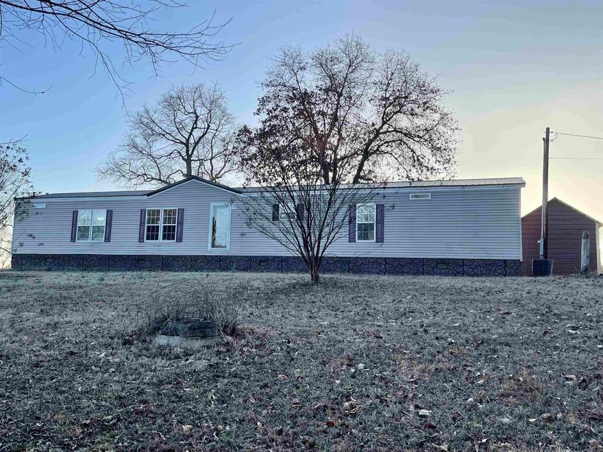 Very nice mobile home on approximately 4.35 acres. 3 bedroom, 2 bathrooms, new roof in 2023, screened-in porch, portable carport, plus a couple of sheds for lots of storage.  The home has a very open, spacious feel.  The property includes plum trees, pear trees, muscadine and blackberry vines, and several great spots for a garden.  Sit outside and enjoy the wildlife that like to play in the yard, or just stare at the beautiful scenery.  There is also an extra place to put another mobile home or park your rv. This place is has a lot to offer, and is really impressive!