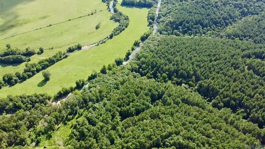 This stunning 5.45-acre tract offers 570 feet of frontage on the clear, scenic Little Piney Creek, with breathtaking views of the water and distant mountains from its elevated position. Enjoy spectacular swimming areas and direct walking access to the creek—ranging from semi-steep to moderate slope.  Privacy is a key feature, with a coded automated entry gate and deeded utility and access easements already in place. Electric is approximately 1,550 feet from the property, and a well will be required. A recent survey is completed, and the land features several excellent building sites, offering flexibility for your dream home, cabin, or retreat.  Most of the land remains in its natural, untouched state, with a small area cleared and ready to begin your vision. Opportunities like this with elevated views and private creek access are rare—don’t miss your chance to own a piece of Little Piney!