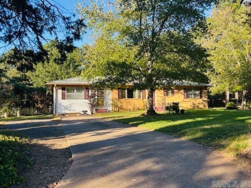 Beautifully maintained 3-bedroom, 2-bath home on Russellville’s desirable west side! Featuring rich hardwood floors, a cozy traditional layout, and thoughtful touches throughout—like a pocket door connecting the living room to kitchen and a stunning stained-glass door leading to the dining room. Relax in the primary bath’s jetted tub after a long day. Roof on home and detached building replaced in 2023. Landscaped yard with charming white picket fence adds the perfect finishing touch!