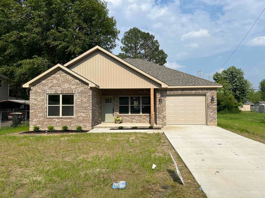 Brand new brick 3 bedroom, 2 bath home with spacious front porch, back porch and patio. The kitchen has dark stained kitchen cabinetry with gorgeous quartz countertops. Kitchen has access to the laundry room with extra cabinetry storage, and is open to the large living area. The primary bedroom has a fantastic custom walk-in closet and an efficient primary bathroom with 7 foot double vanity with storage, and spacious tiled shower. The home is all-electric and is heated/cooled by a high efficiency heat pump system. LVT flooring and 9' ceilings throughout. Garage is deep. Partial fenced yard, left side shared with neighbor. One-year builder warranty. Agent and Builder owned.