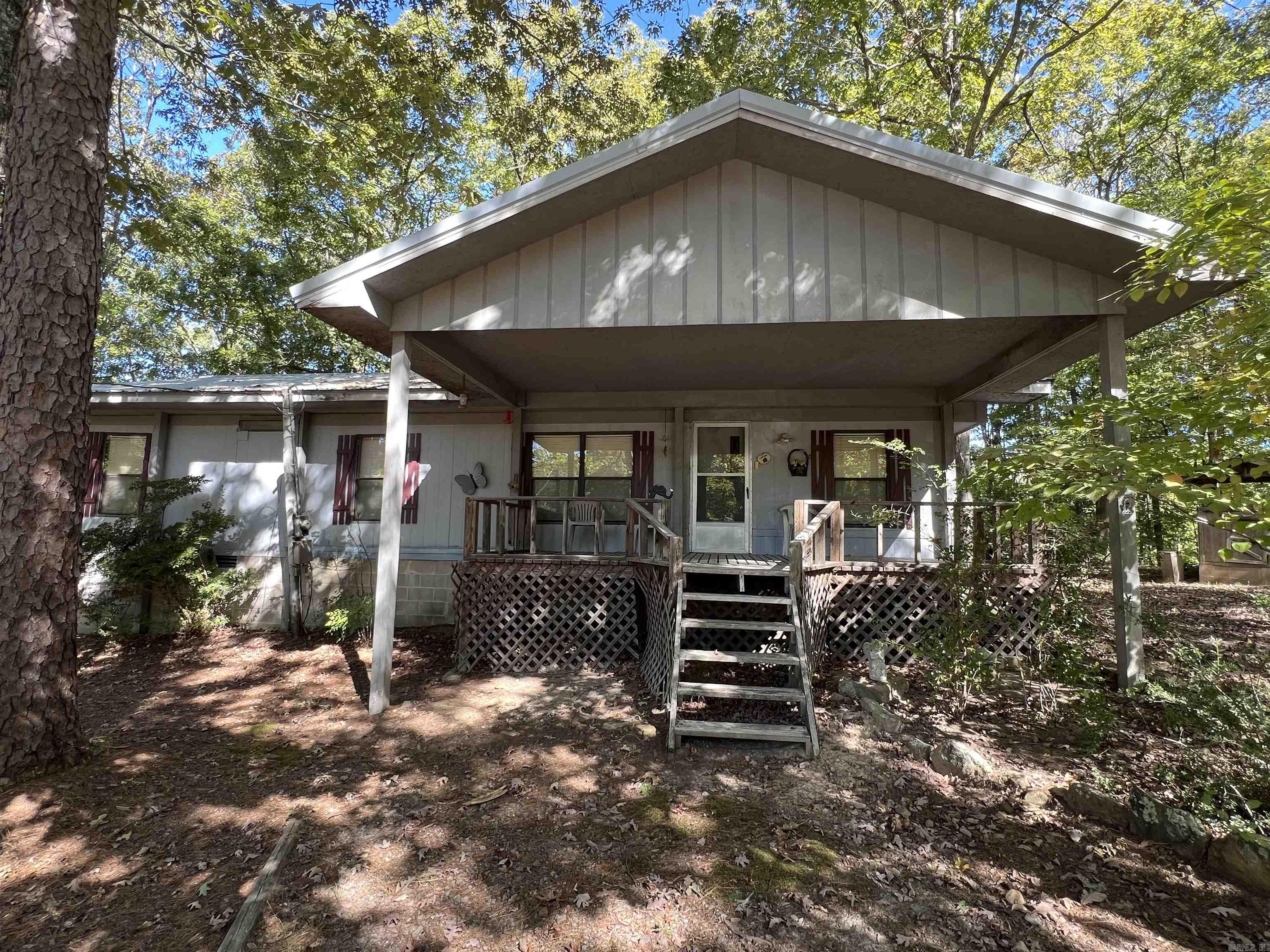 LAKEFRONT oasis on Greers Ferry Lake for sale. Escape to your serene retreat with this charming 2-bedroom, 1-bath mobile home nestled on 1.59 acres, perfectly situated on the shores of Greers Ferry Lake. Enjoy stunning water views and the tranquility of nature from your own piece of paradise. This well-maintained home features a cozy wood-burning stove, providing extra warmth and ambiance during cooler months. The property comes fully furnished, making it move-in ready! The mobile home is set on a permanent foundation, has a new metal roof, and sits on three spacious lots, offering ample room to expand or build your dream lakefront home while enjoying the comforts of the current residence. With low White Line and Red Line designations, the possibilities are endless! Experience the freedom of no restrictions on property use—perfect for personal enjoyment, investment, or development. Mineral Rights do not convey to new owner. Whether you’re looking for a weekend getaway or a year-round escape, this property offers a unique opportunity to embrace the lake lifestyle. Don't miss your chance to own a slice of paradise on Greers Ferry Lake! Schedule your private showing today!