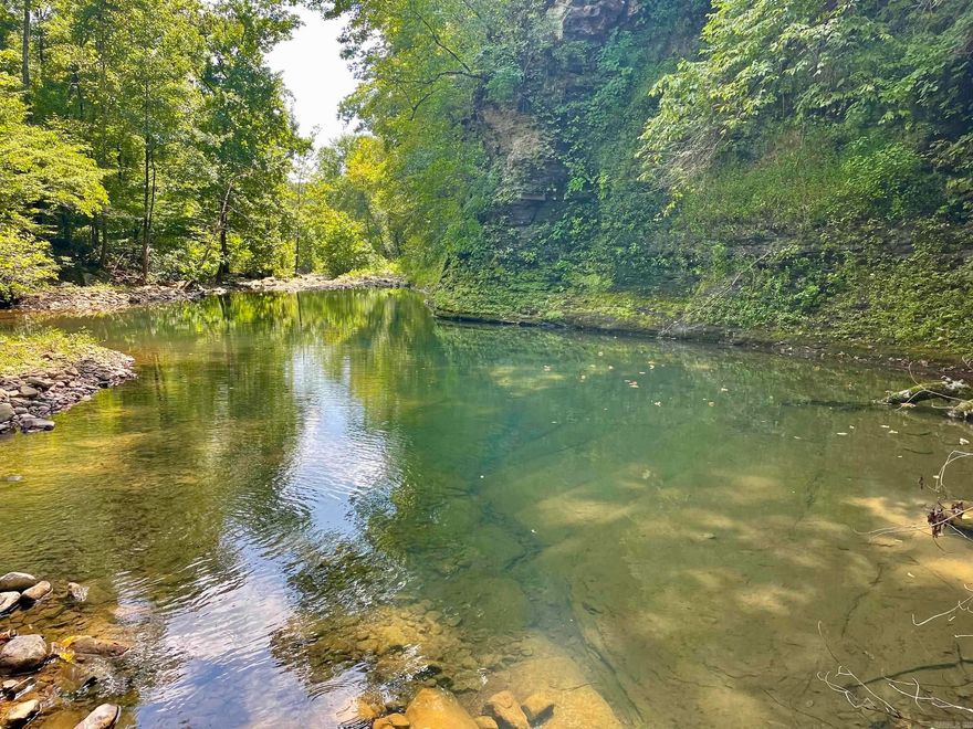 Tucked deep in the heart of the Ozark Mountains, this completely off-grid property is a hidden gem for those seeking true seclusion and natural beauty. Though rugged and remote, a logging road leads to the property, making it accessible by four-wheel drive, especially to the banks of the stunning Archey Creek. With over 1,000 feet of year-round creek frontage, you’ll enjoy wading pools, bubbling rapids, and a breathtaking swimming hole framed by a shaded bluff on one side and a peaceful gravel bar on the other. It is Ideal for picnics, camping, fishing, or just unplugging with family and friends. Smallmouth bass and a variety of panfish make this a great spot for anglers. Surrounded by mature hardwoods and teeming with wildlife - deer, turkey, and even black bear - this land offers multiple building sites perfect for a rustic cabin or seasonal getaway. Scattered cabins along the creek hint at a quiet, like-minded community nestled in the wilderness. Please note: while there is a road to the property, it is privately maintained and does not currently offer legal access.